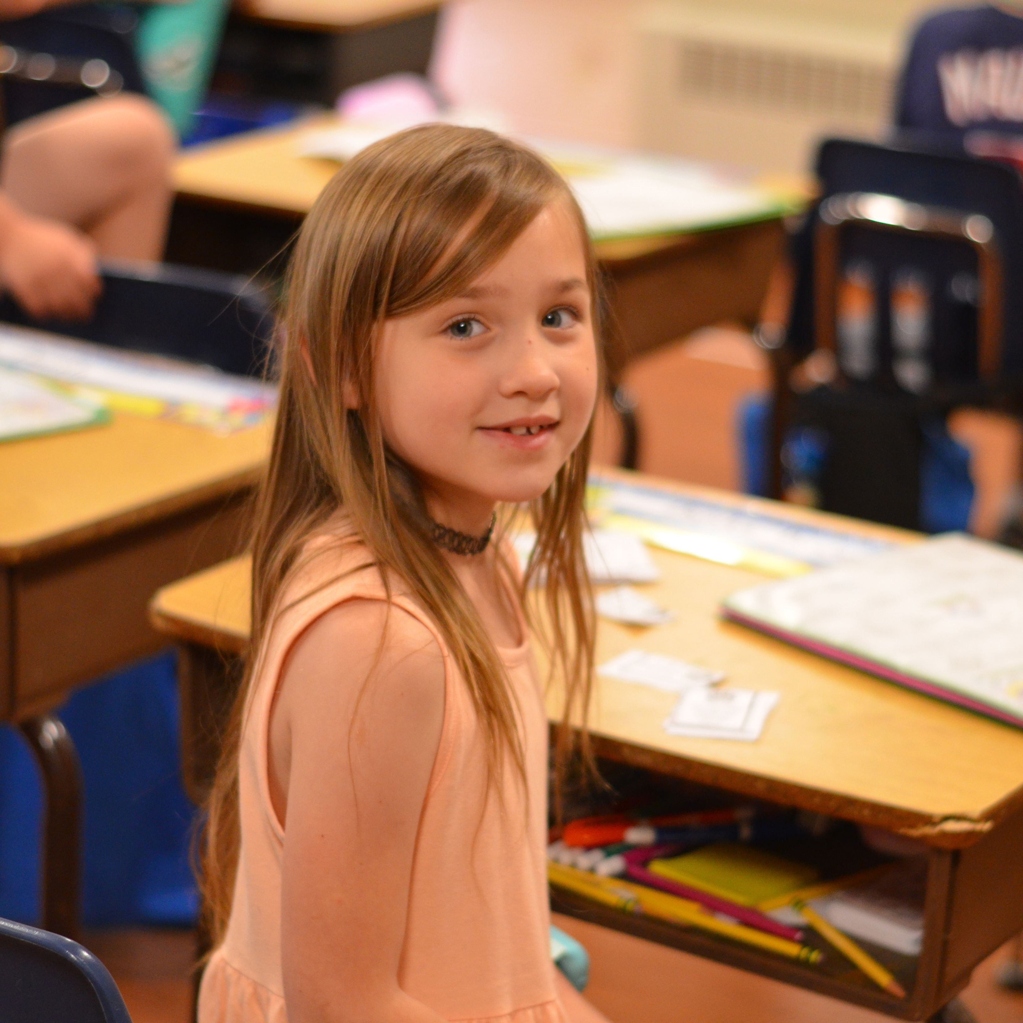 A student looking at the camera over her shoulder