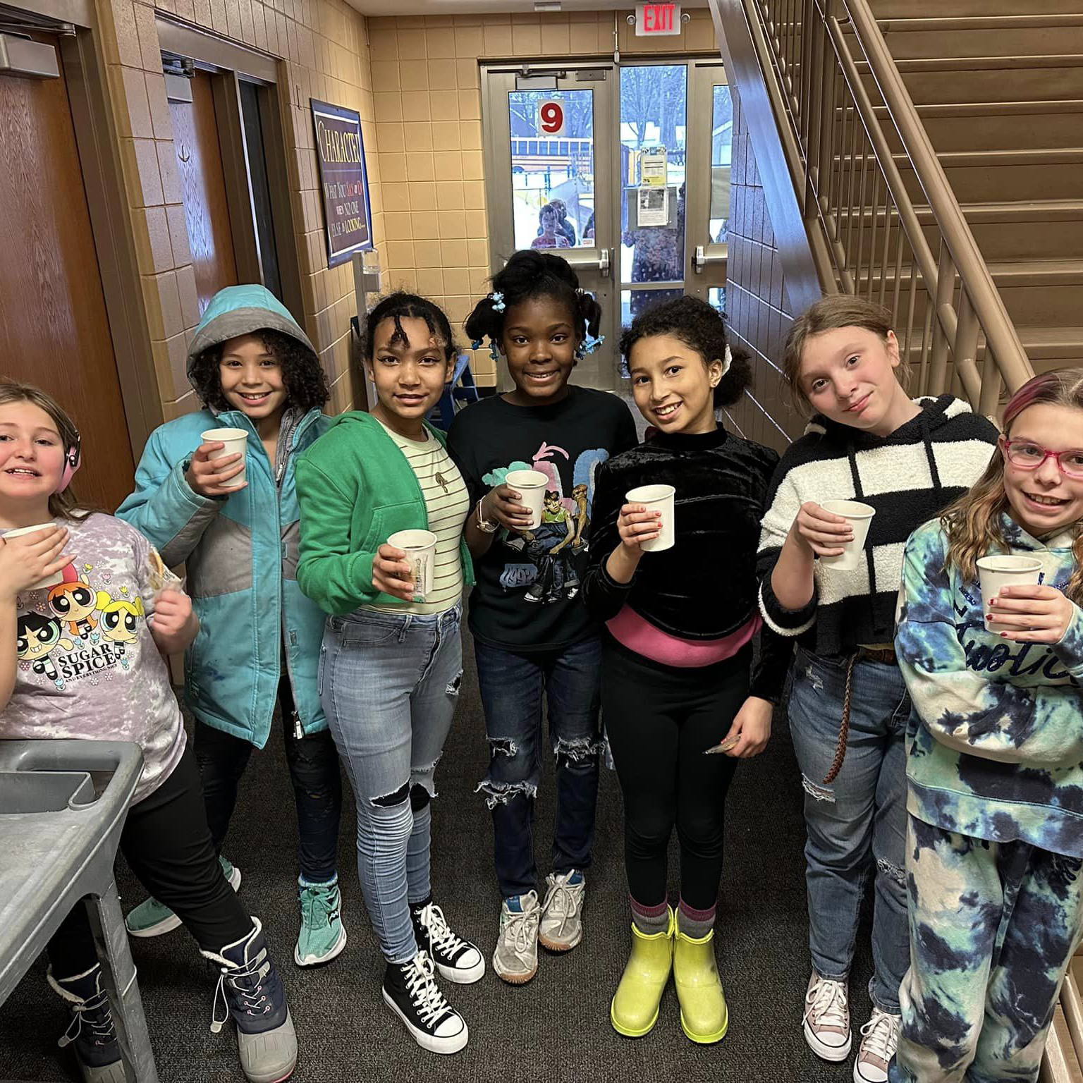 A group of students drinking hot cocoa, smiling at the camera