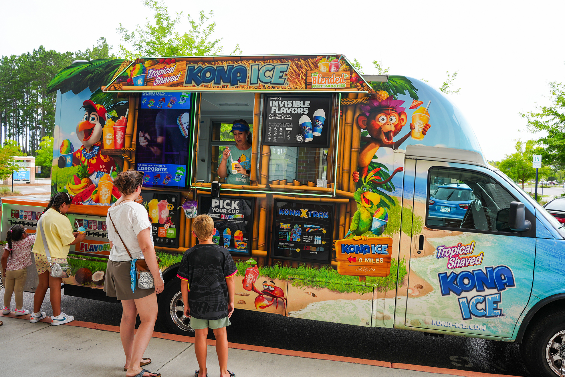 A brightly colored truck with "KONG ICE" written on it. A few people stand in front of it.