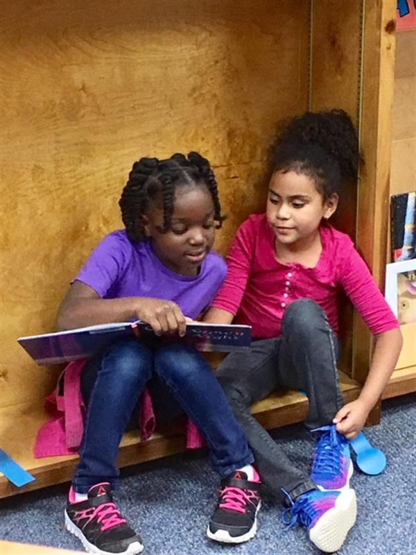 two girls reading in library