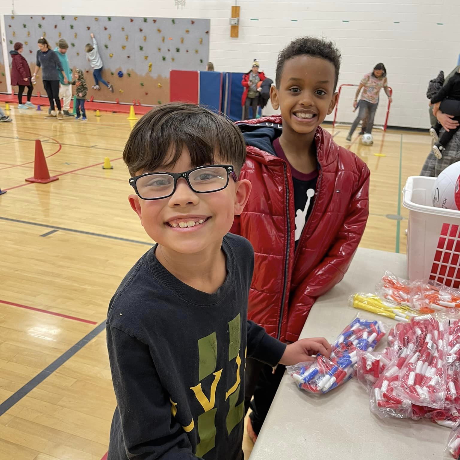 two students in the gym, smiling at the camera