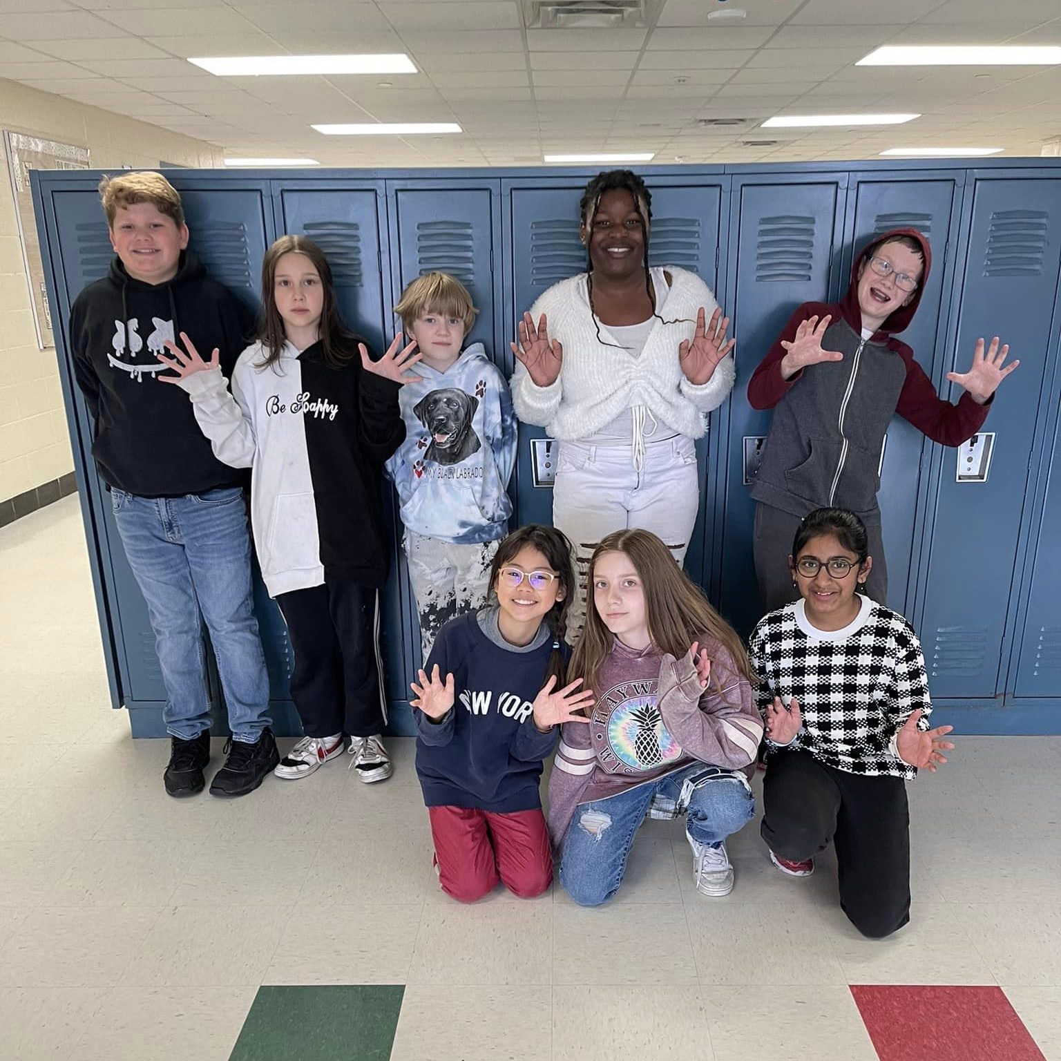 A group of students standing in front of the lockers