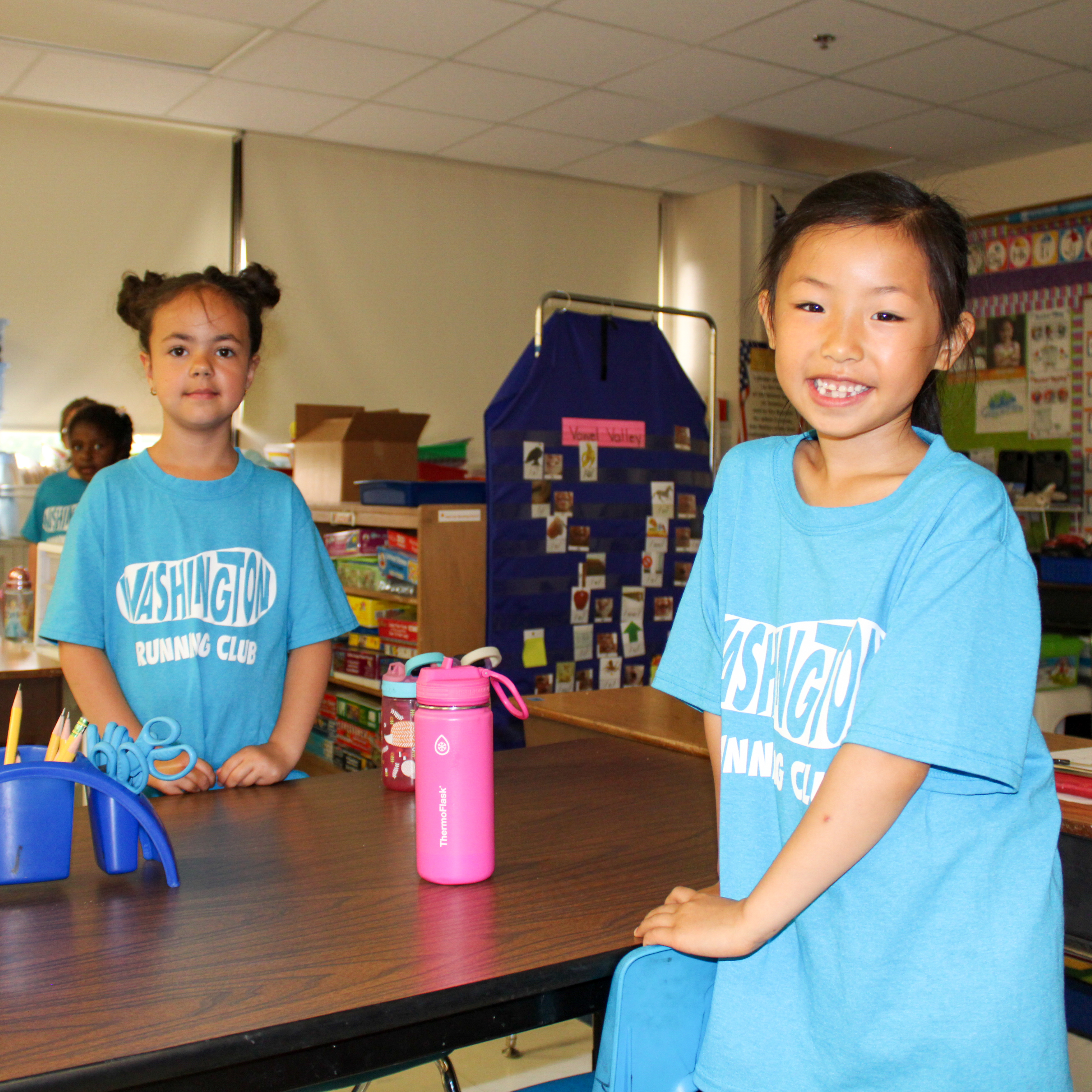 Two students standing across from each other at a desk