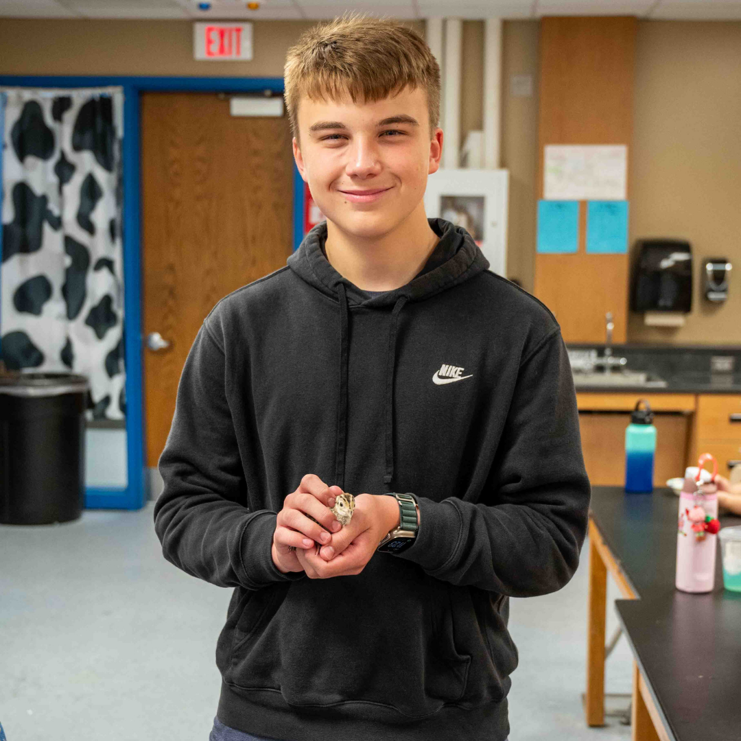 Student holding a bird in science class