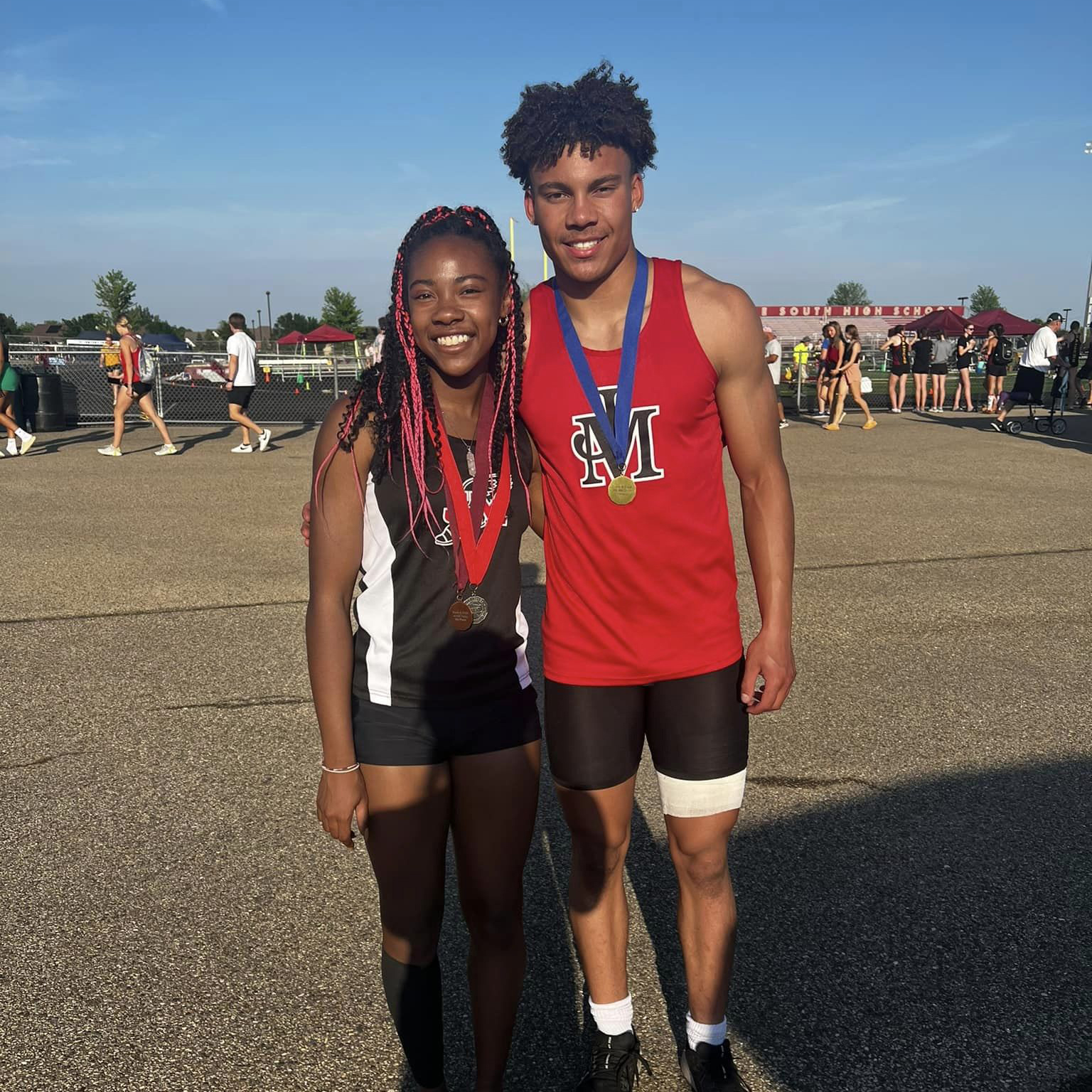 Two student athletes with medals around their necks