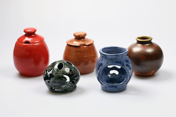 a variety of small handmade pots varying in colors