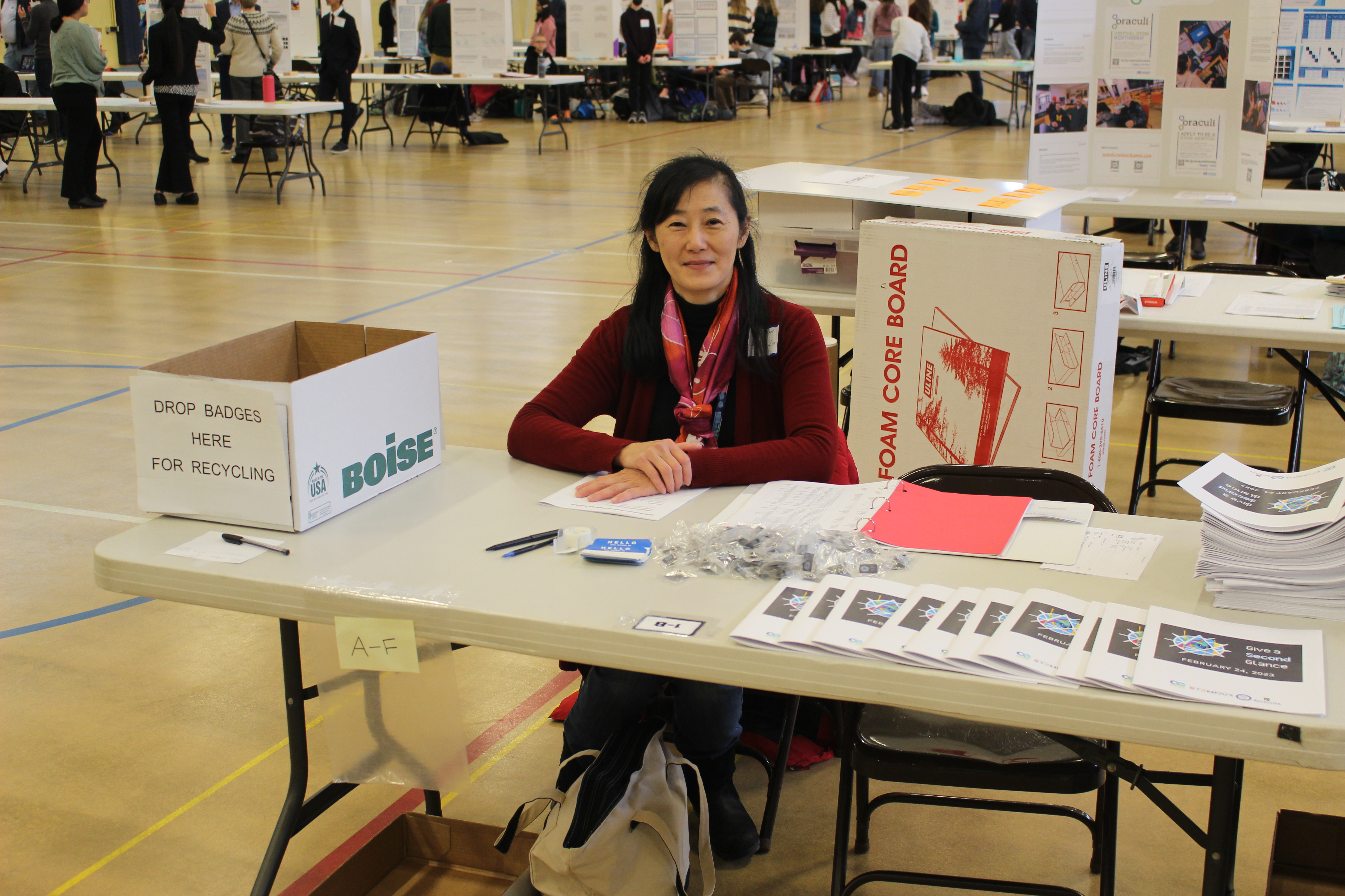 women sitting at table surrounded by STEM Fair supplies