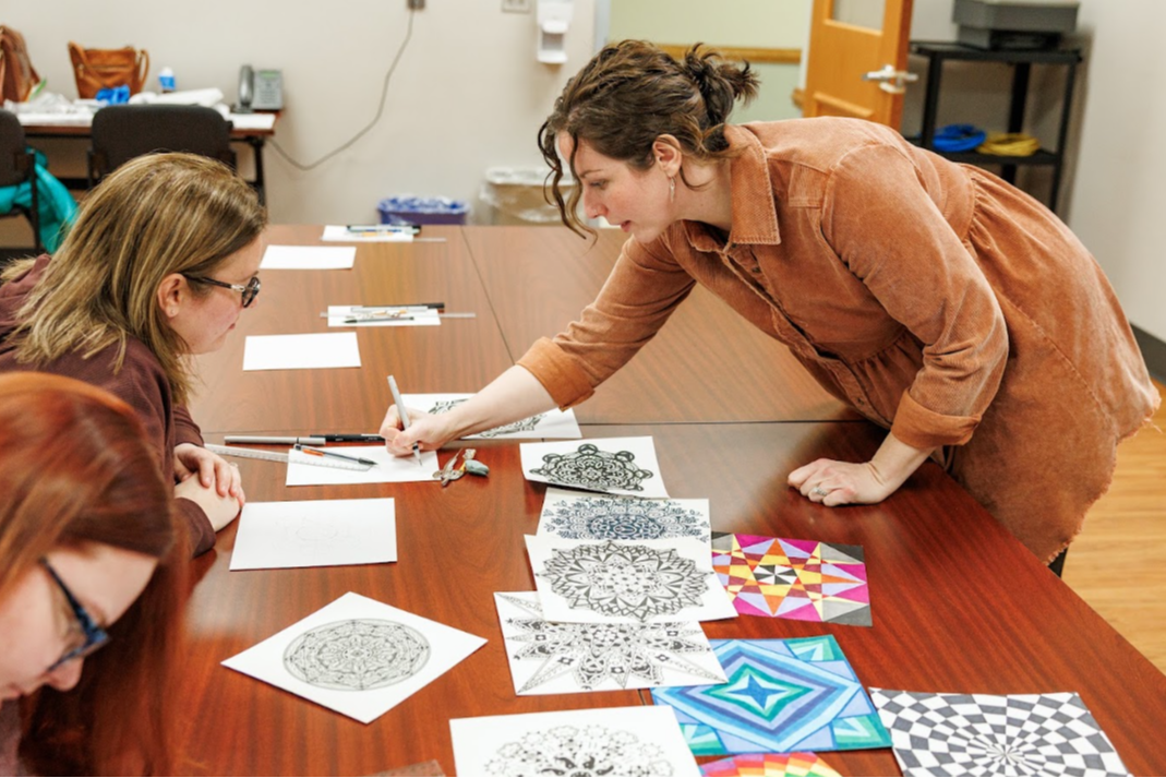 teacher and student working together on a mandala
