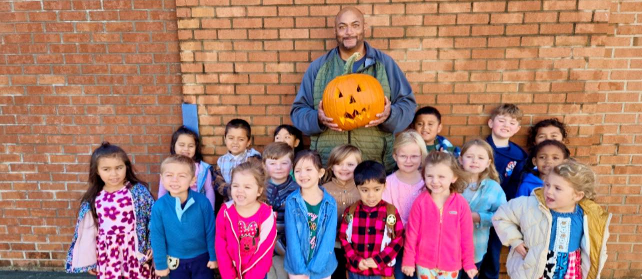 Students pose with Jack-O-Lantern