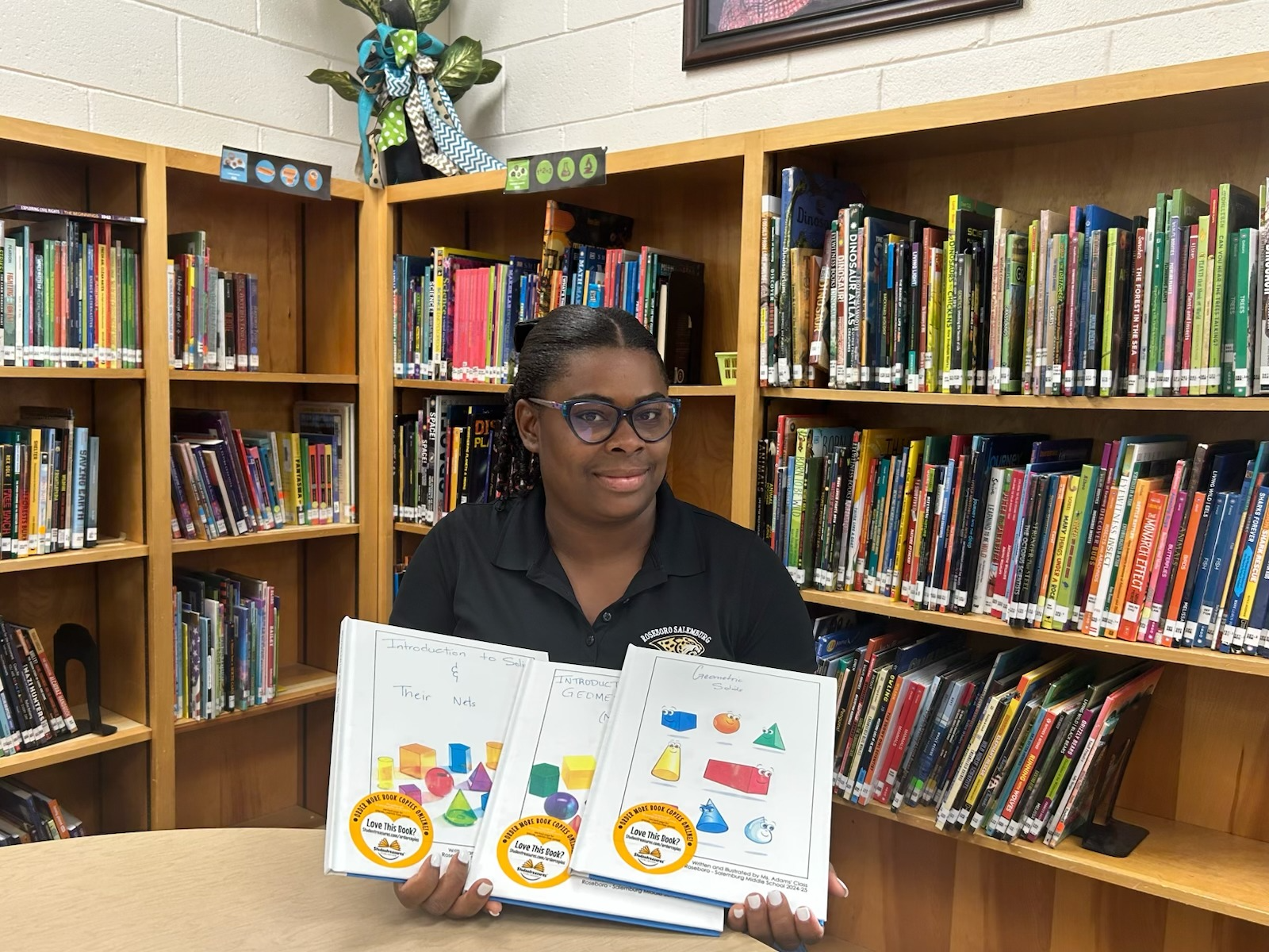 image of Ms. Adams in front of library book shelves