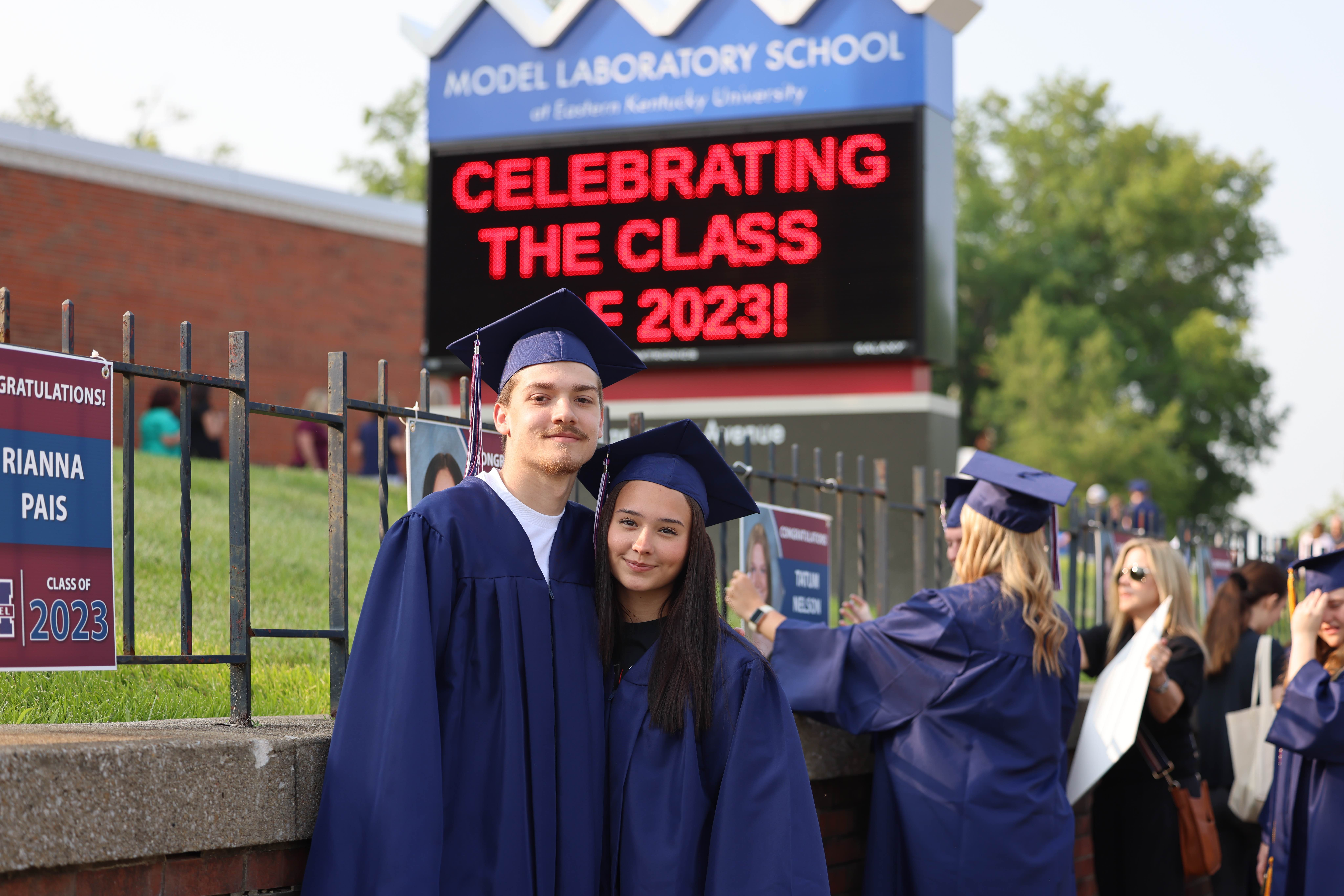 grads in front of sign