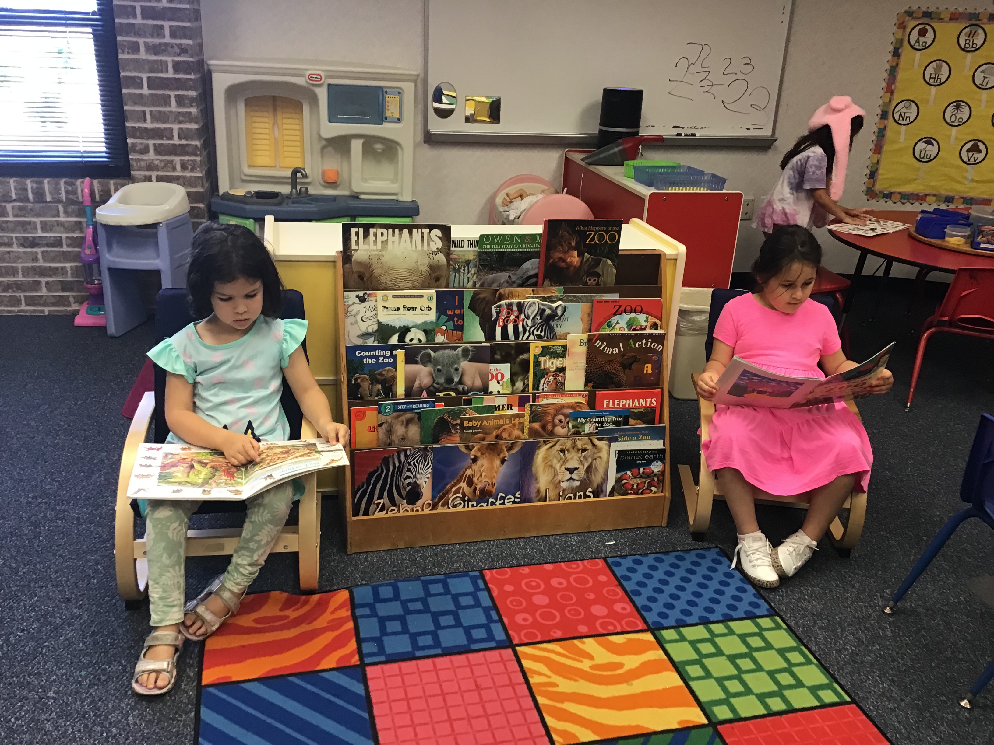 Students sitting in chairs reading books at the reading center.