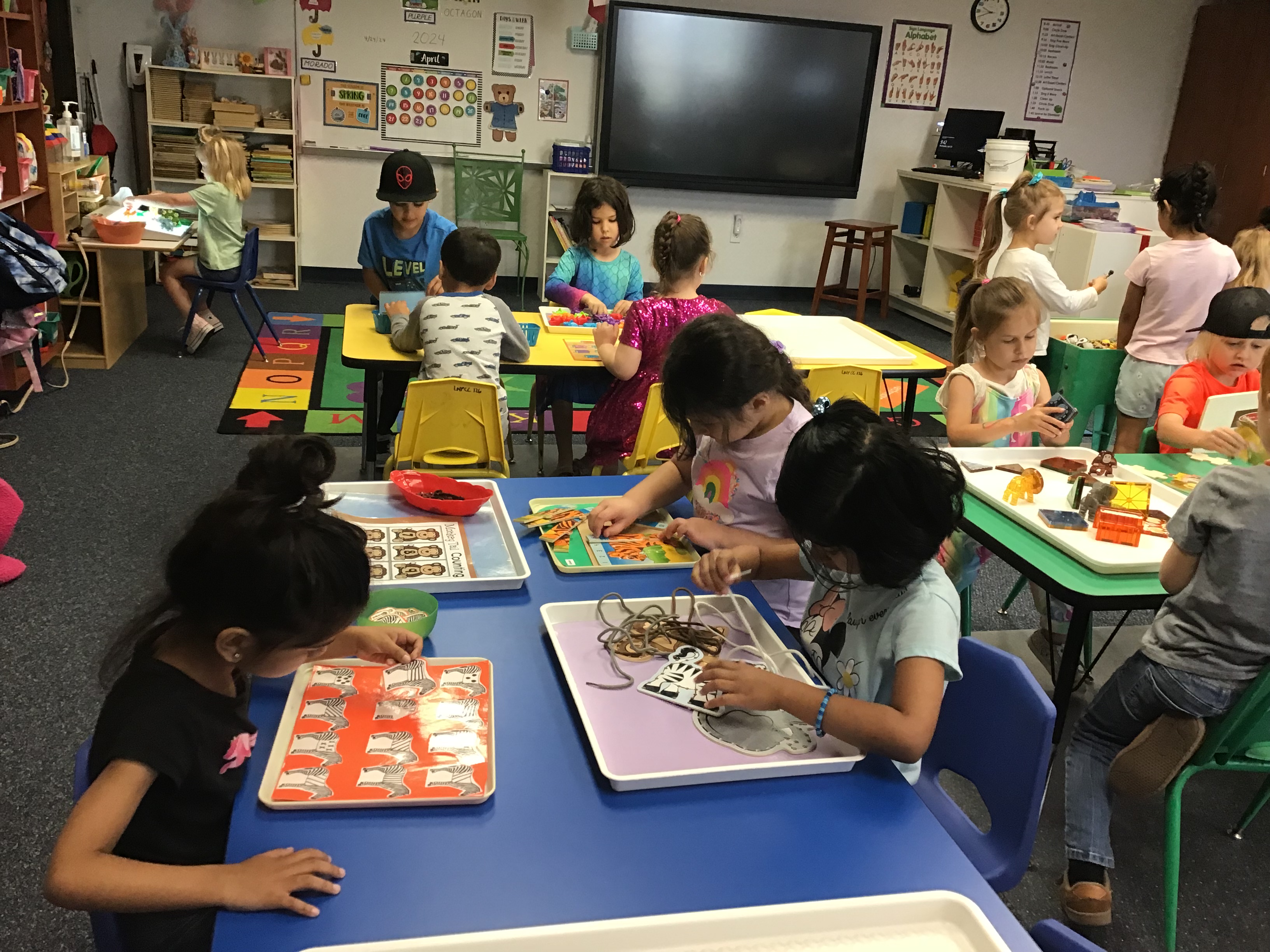 Students at the math center counting zoo animals and completing an elephant puzzle.