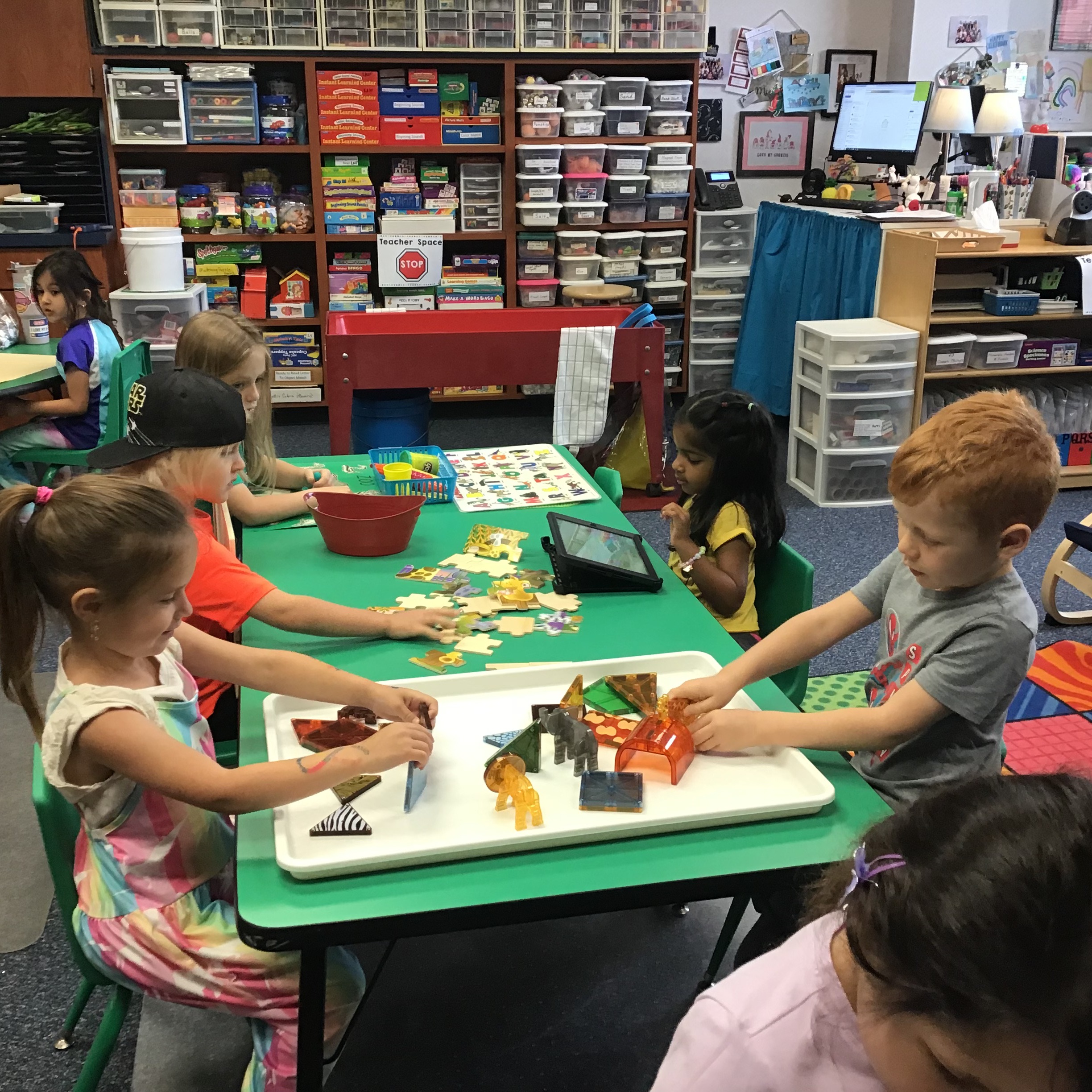 Students playing with zoo magnatiles and completing a zoo puzzle.