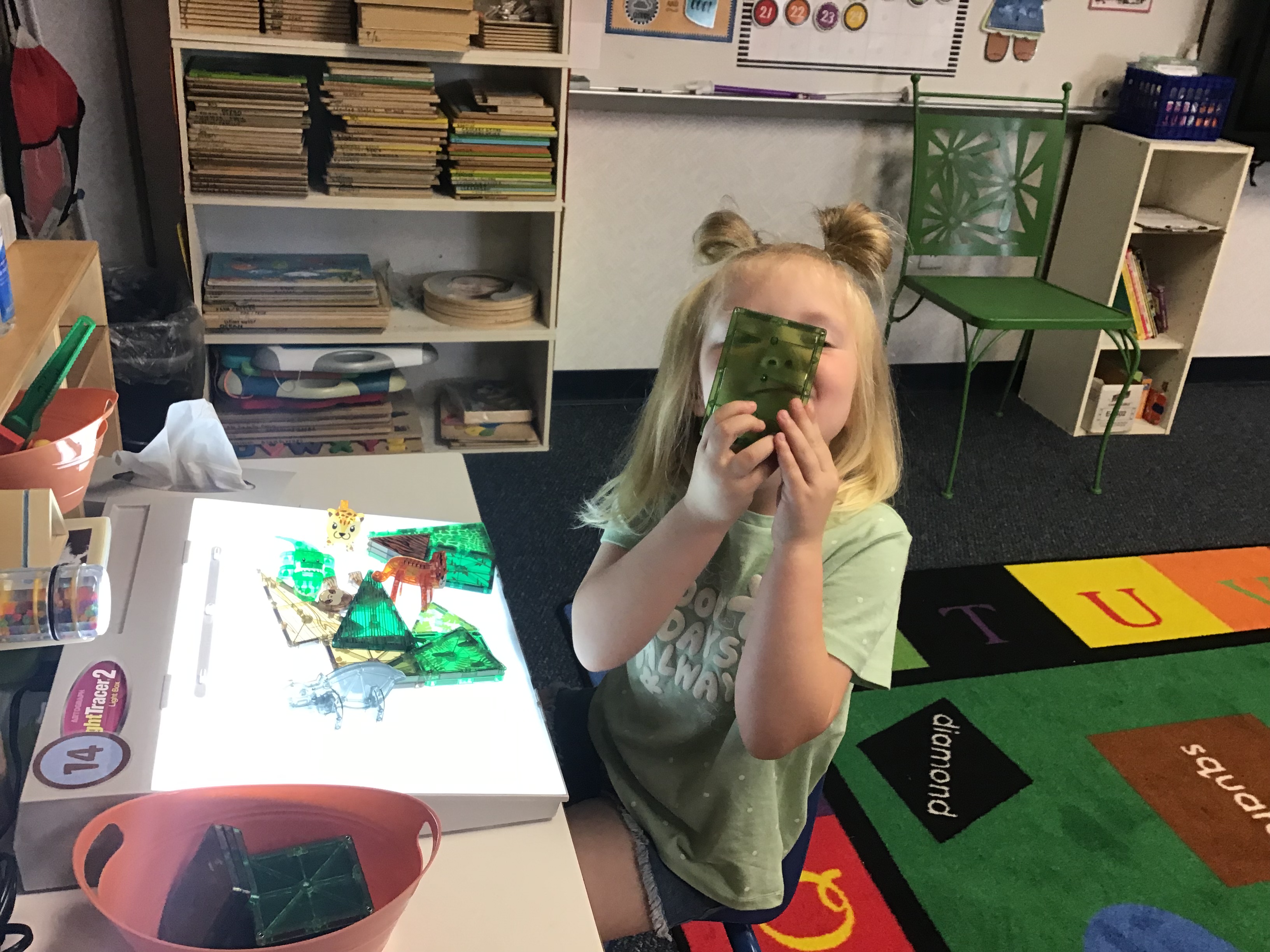 Student using the light box with magnatiles.