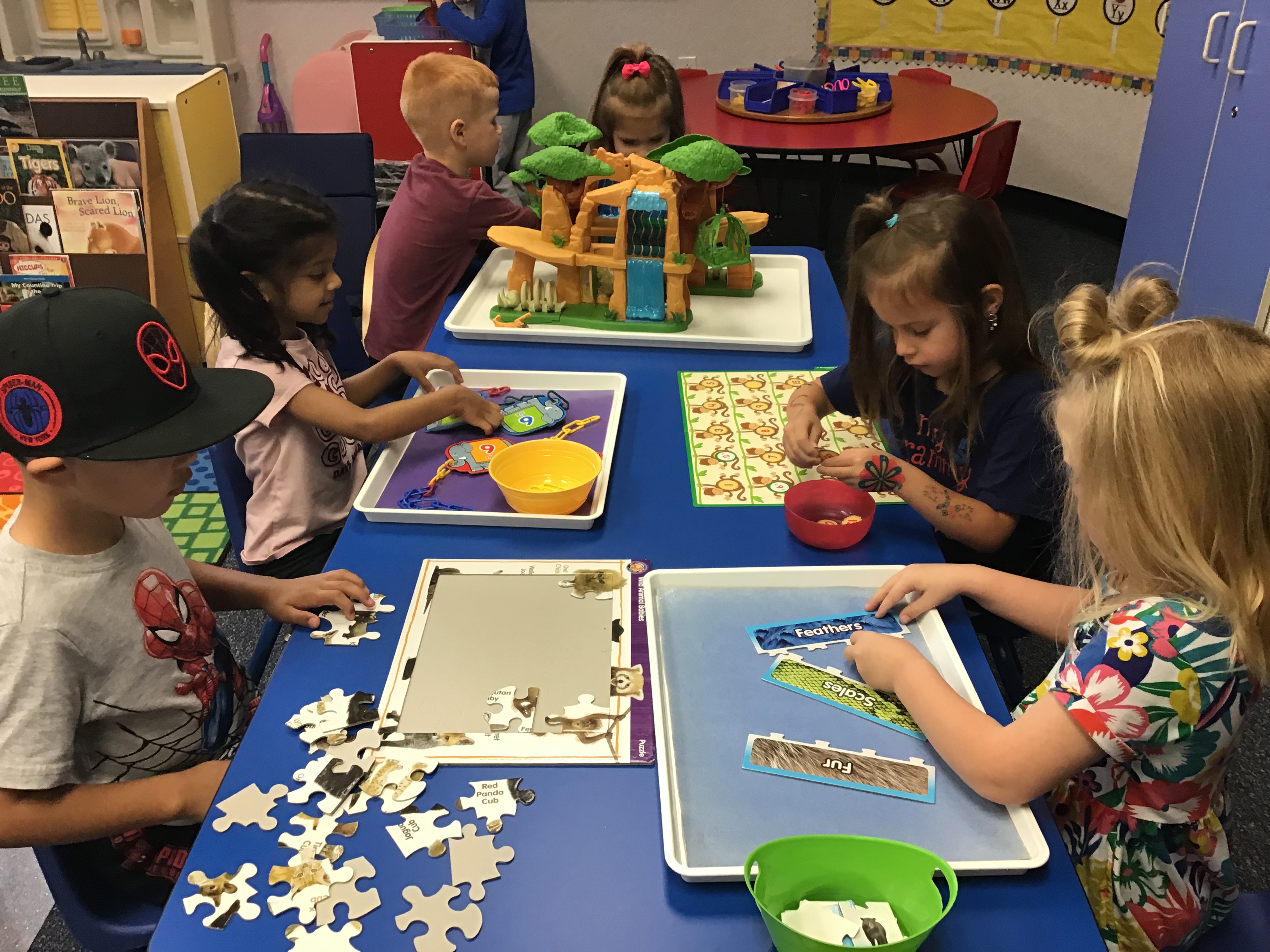 Students at the math center counting monkeys and completing a zoo puzzle.
