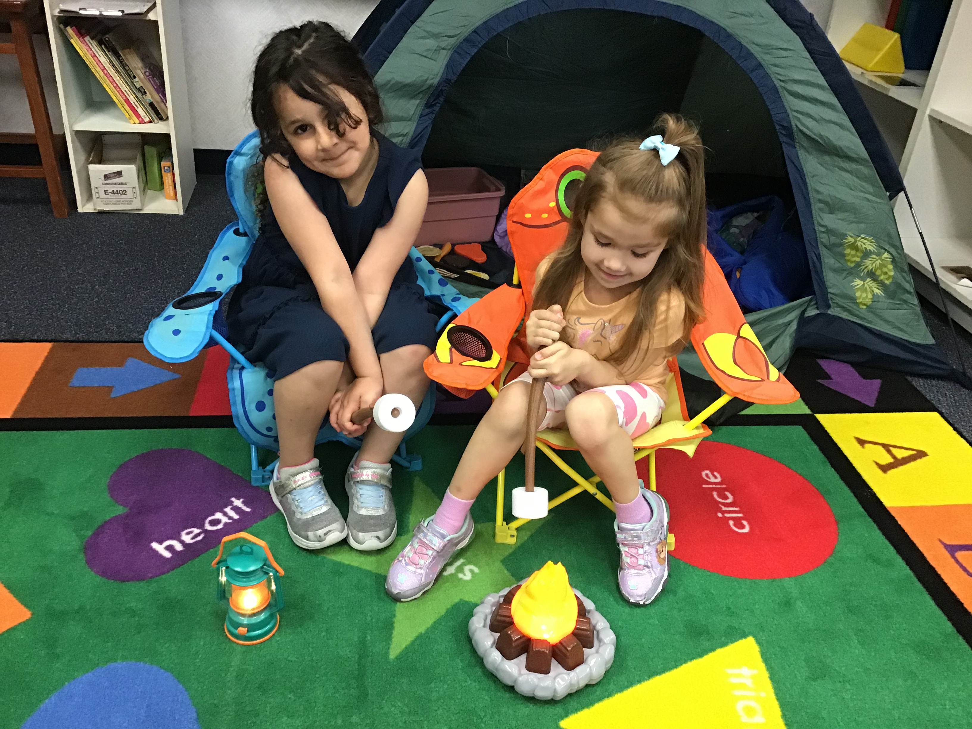 Two students playing in the tent at the block center.