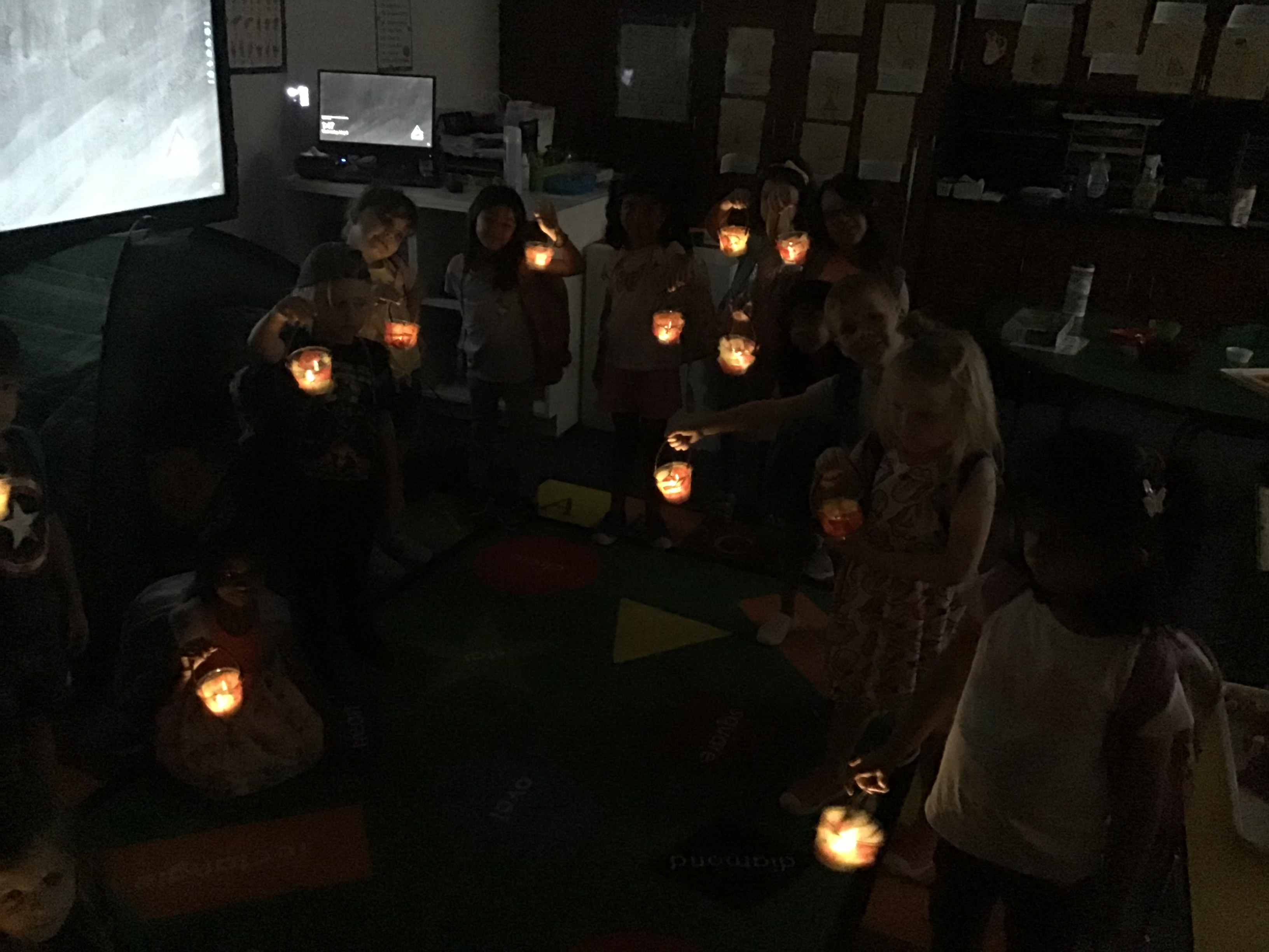 Students holding up their twinkling lanterns that were made for Art.