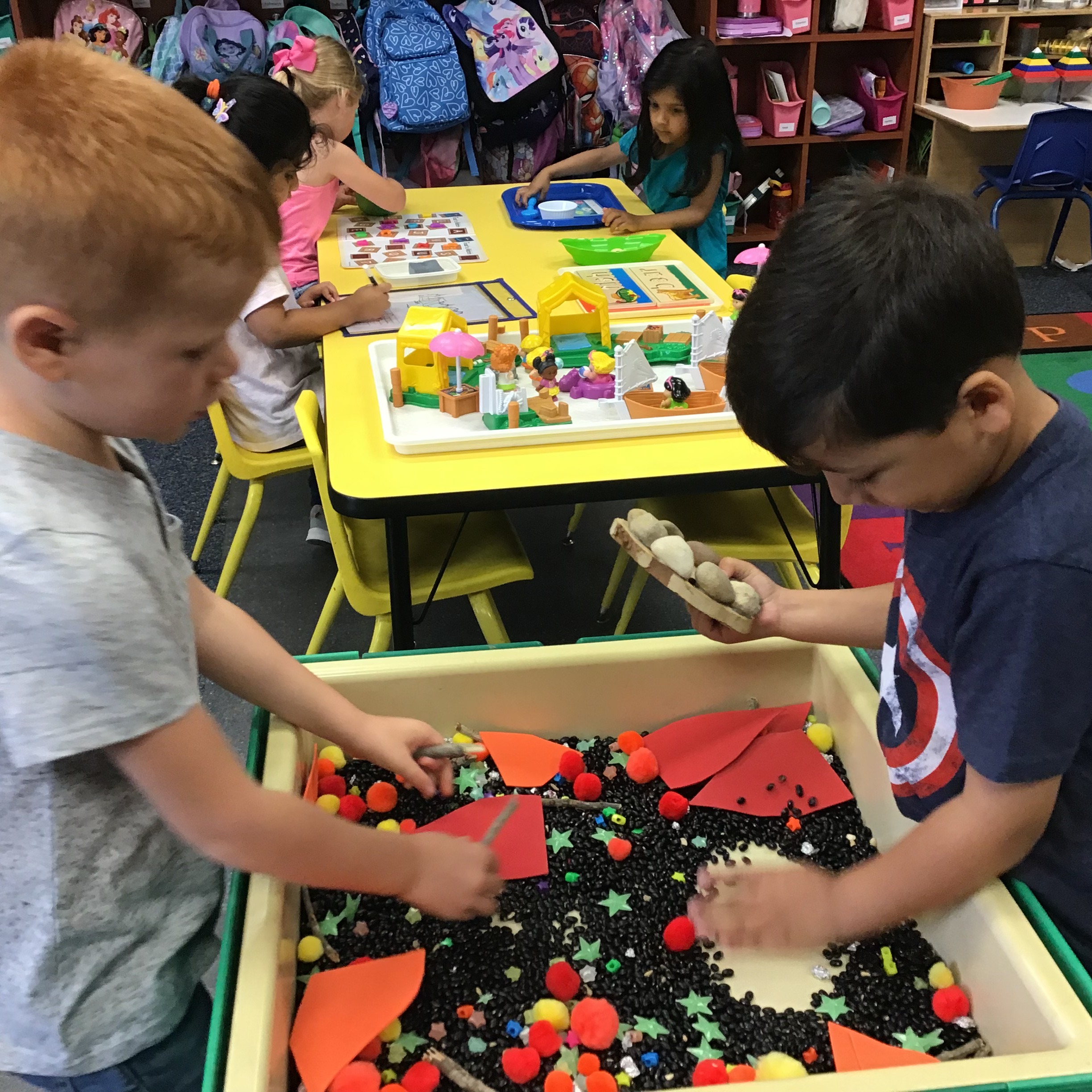 Two kids playing at the sensory table