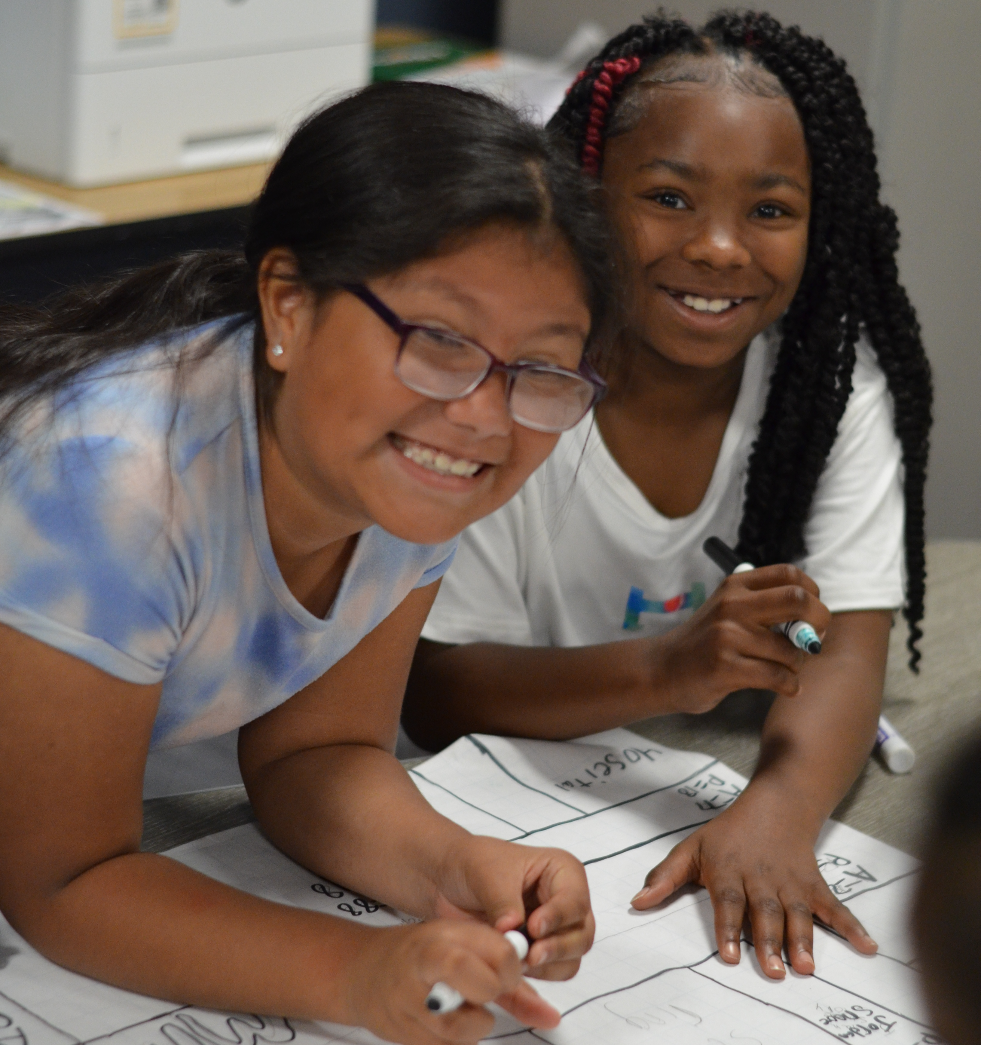 Image of two female students working together on a calendar project in class.
