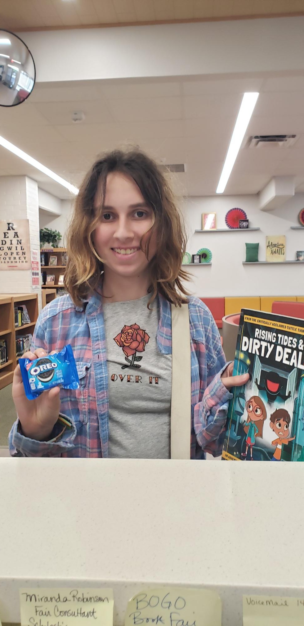 student holding a book and oreo cookies