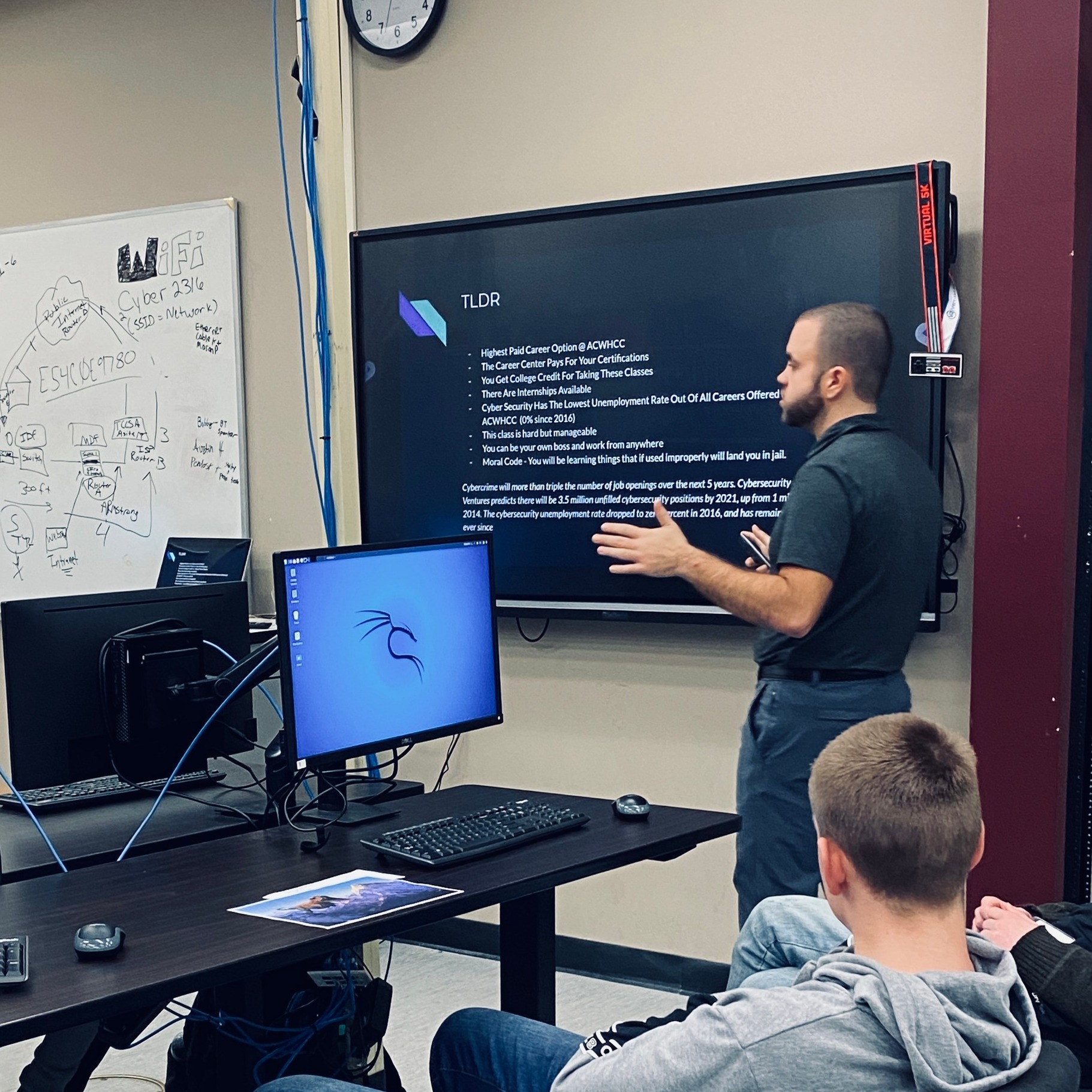 Man teaching class while presenting on screen