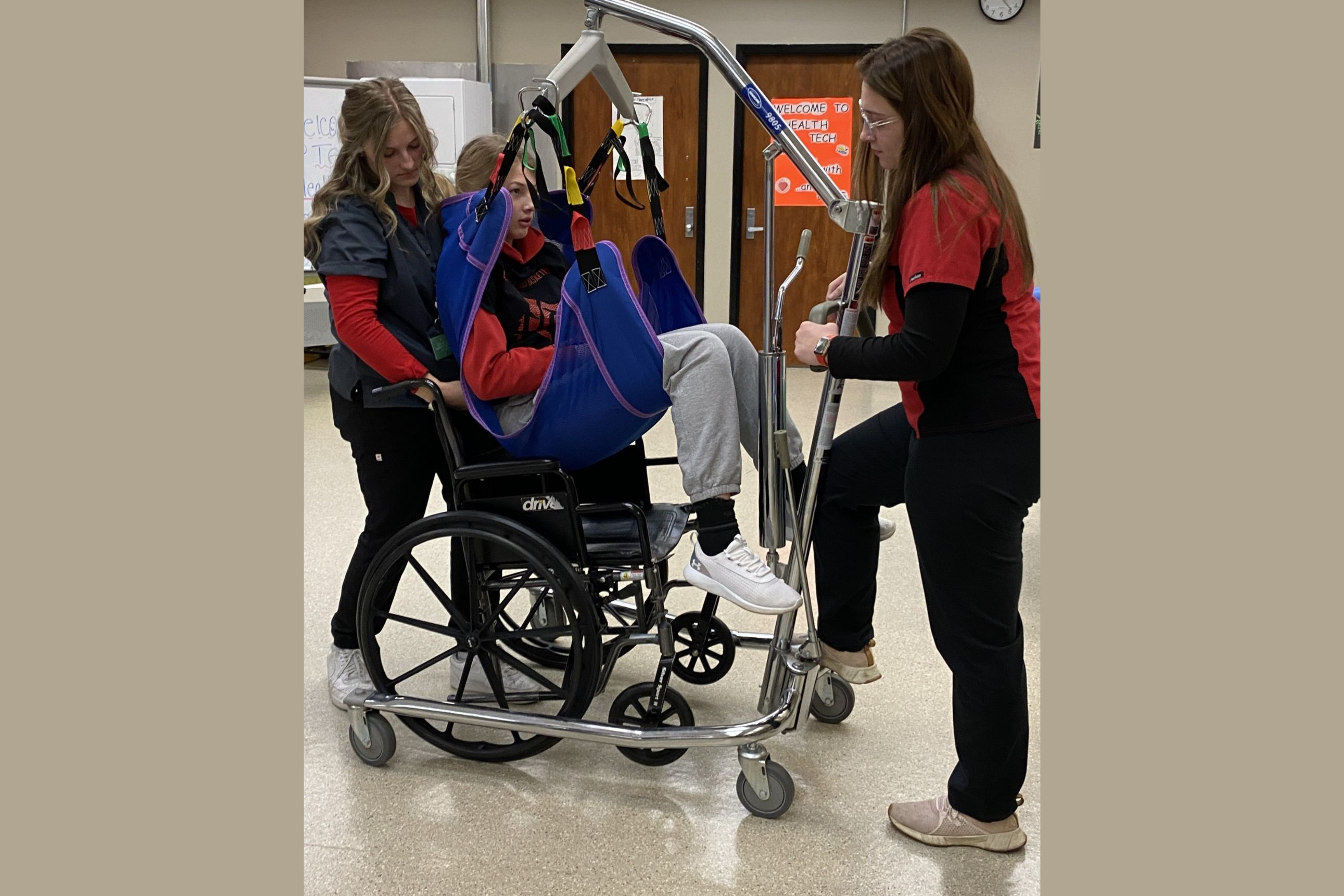 Nursing Students helping patient get into wheel chair
