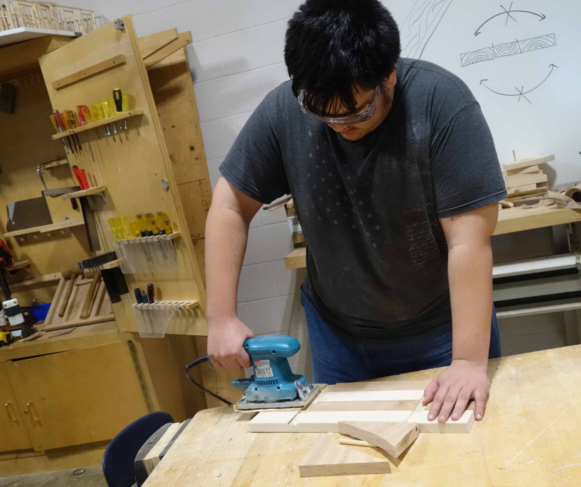 student sanding wood