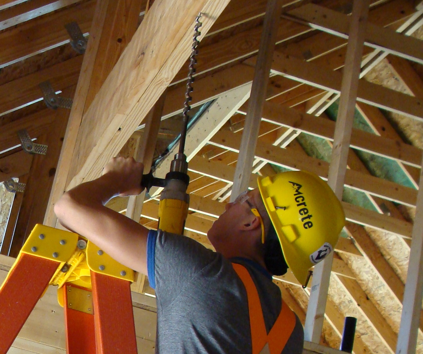 Man drilling through a beam