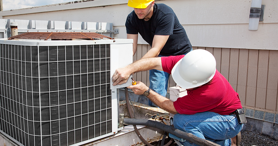 HVAC workers working on air conditioning unit