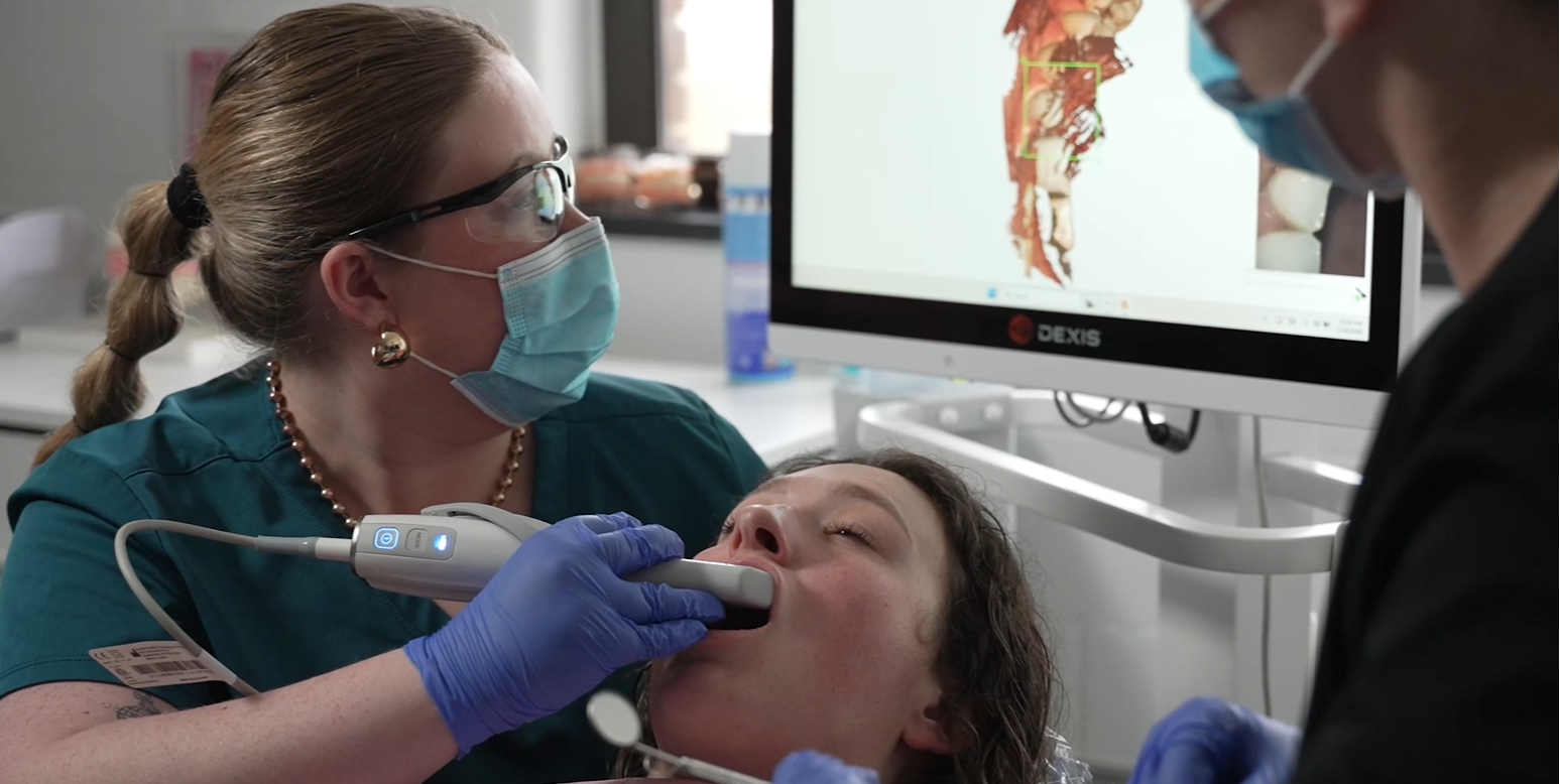 Woman receiving dental assistance from two other.