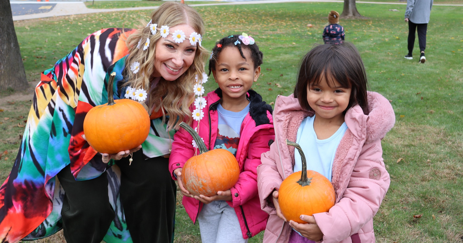 Principal Ey and two students holding pumpkins
