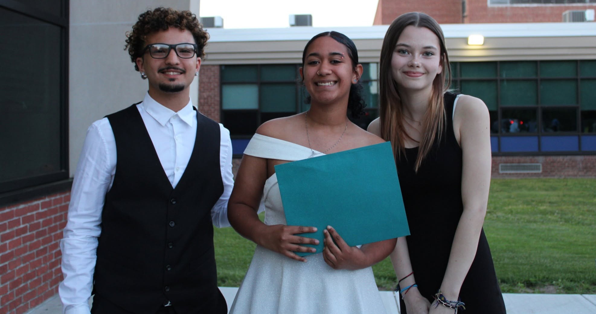Three students pose outside