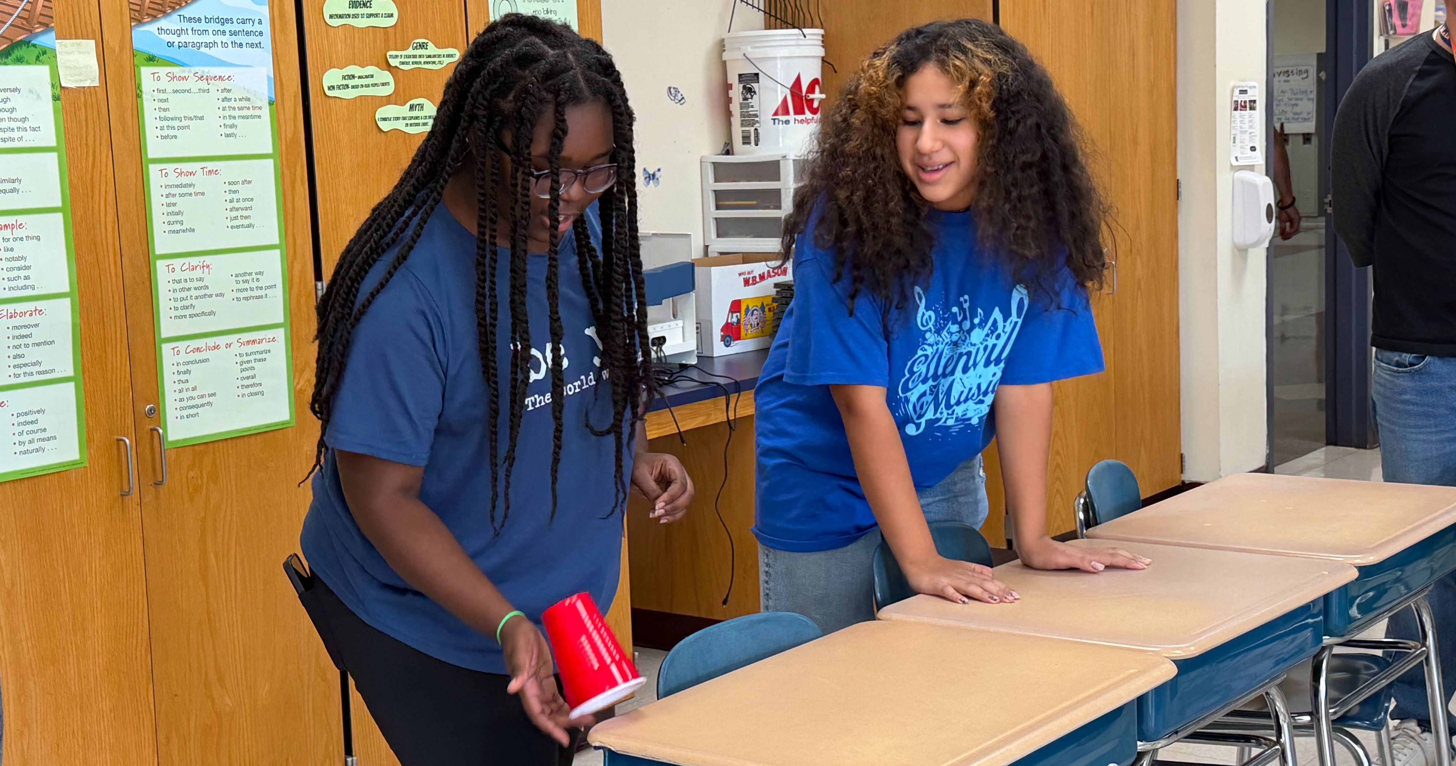 Two students work on a cup stacking challenge