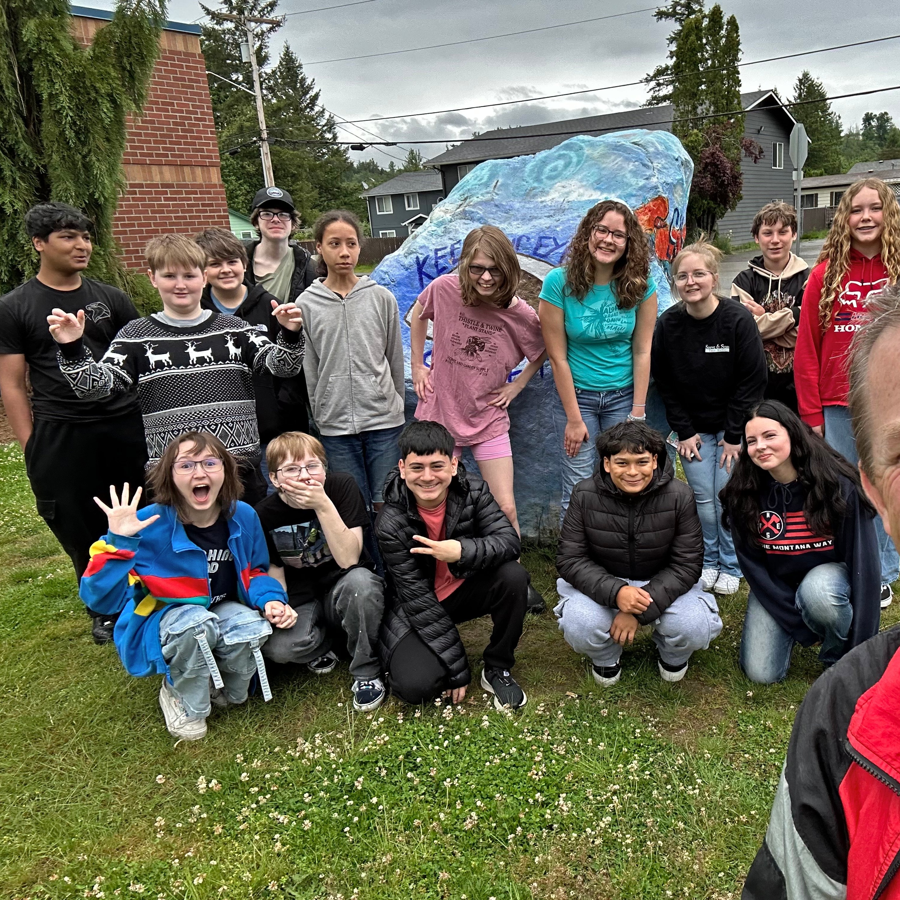 group of students in front of the big rock