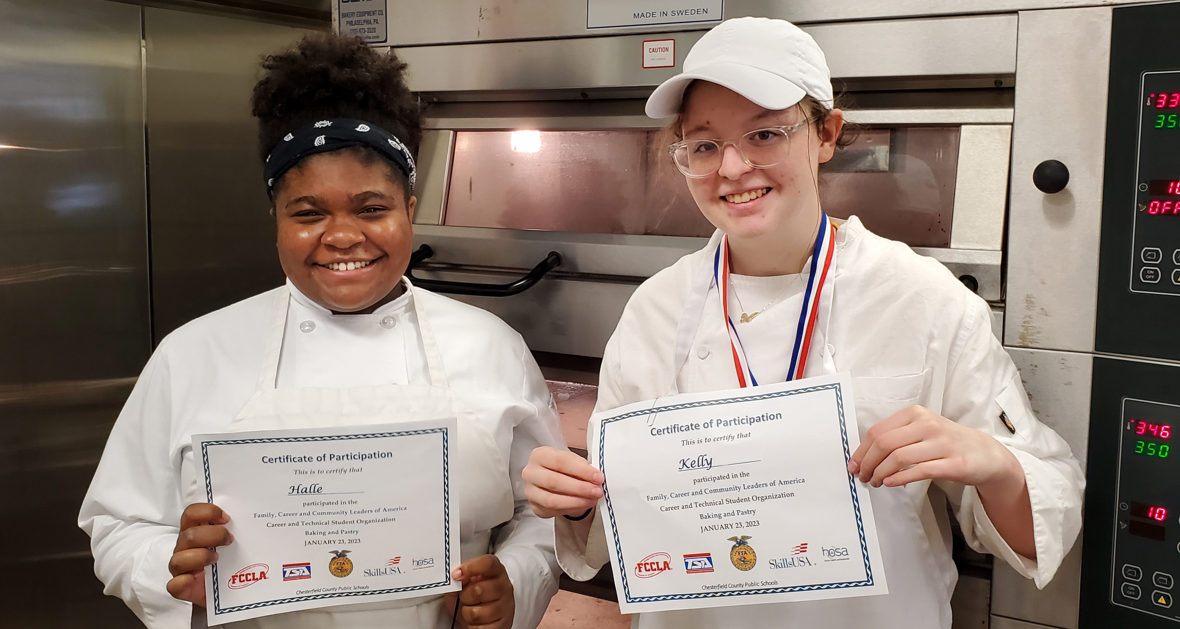 Two culinary students holding a certificate