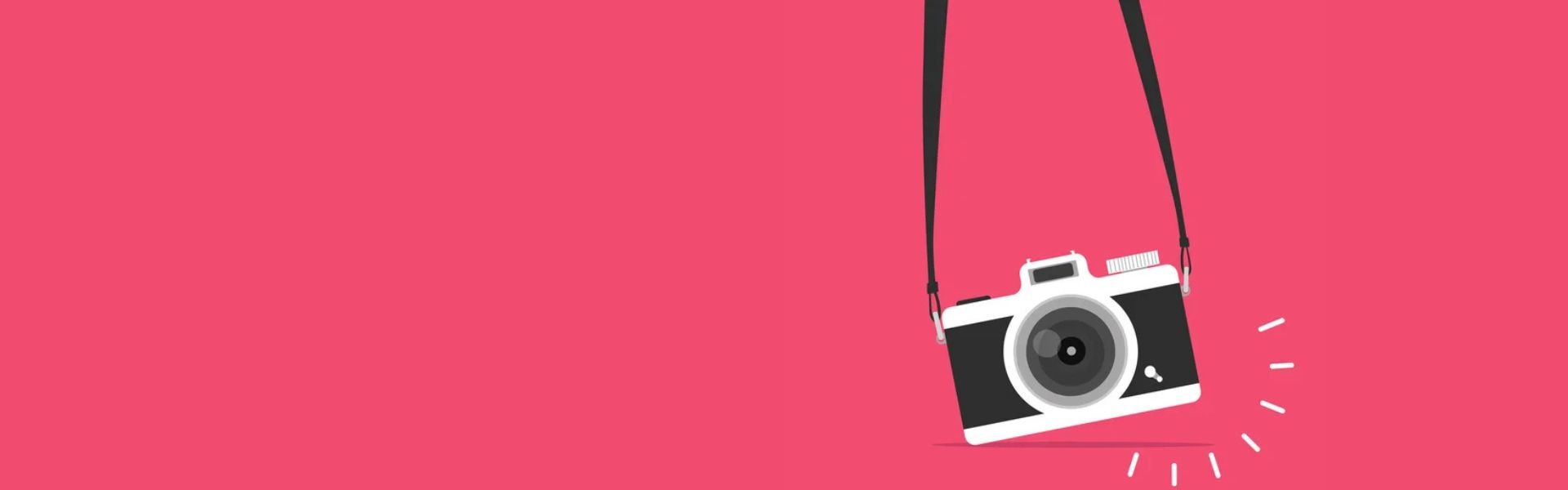 Image of black and white camera hanging from a black strap.
