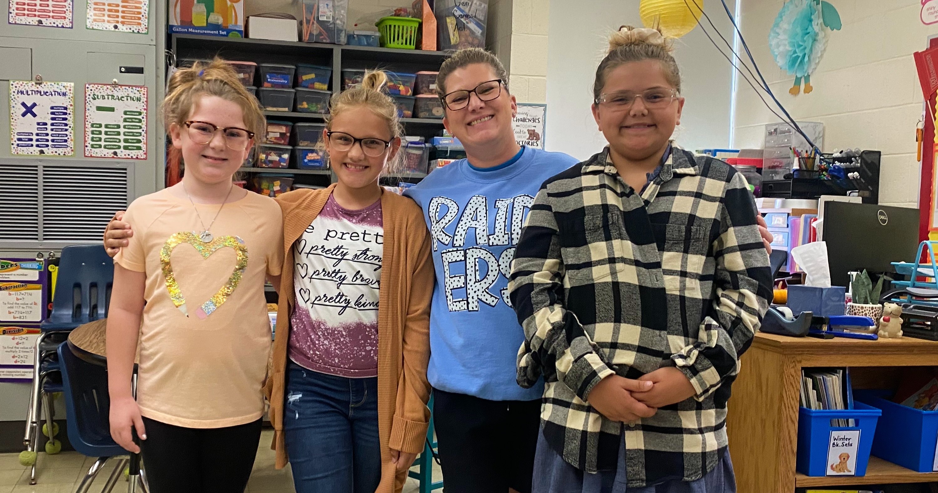 Three students are dressed like their teacher and the teacher is dressed like a student. 