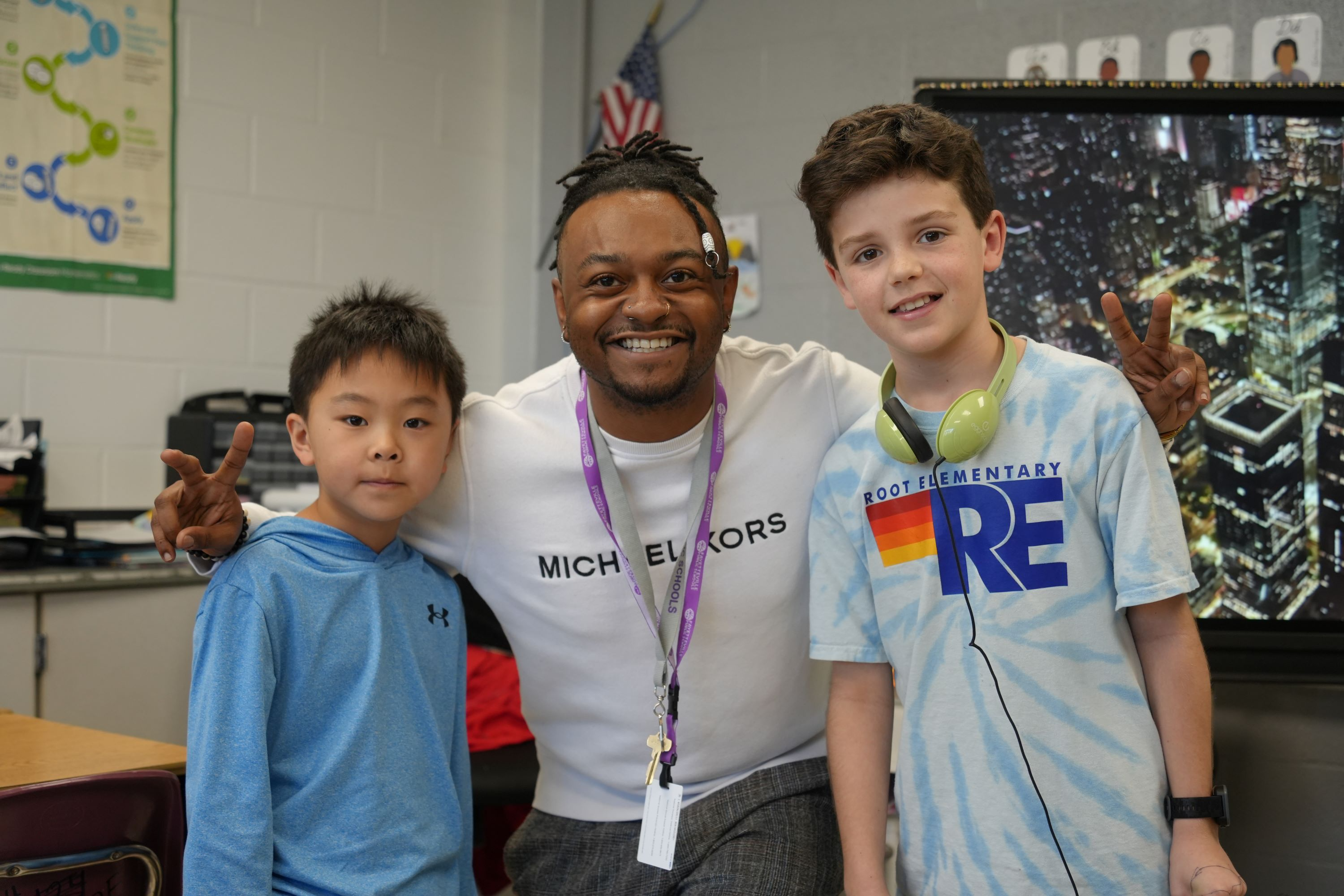 Teacher smiling at the camera with students.