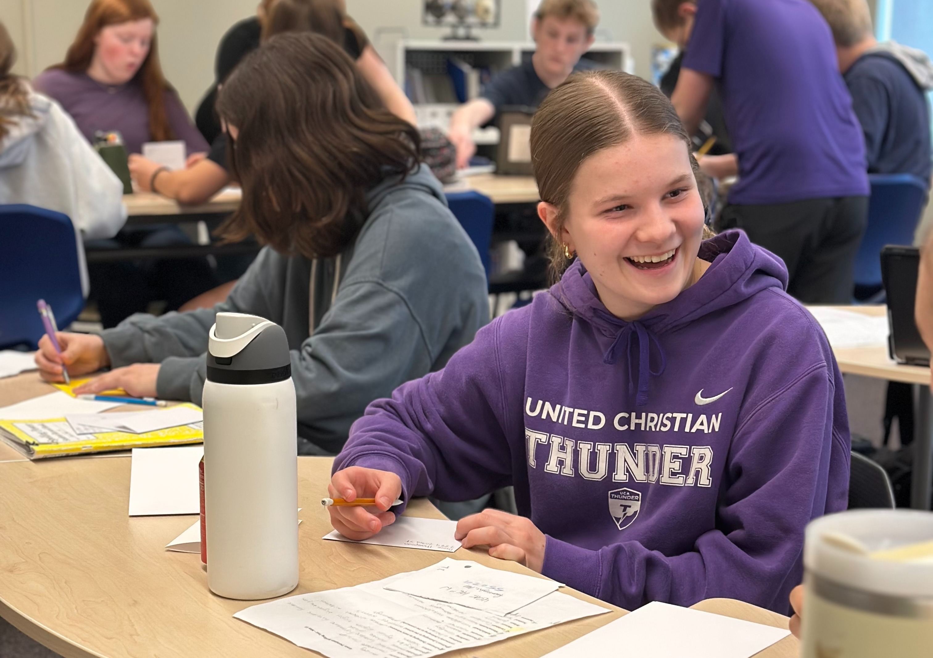 student looking at her desk neighbor and smiling
