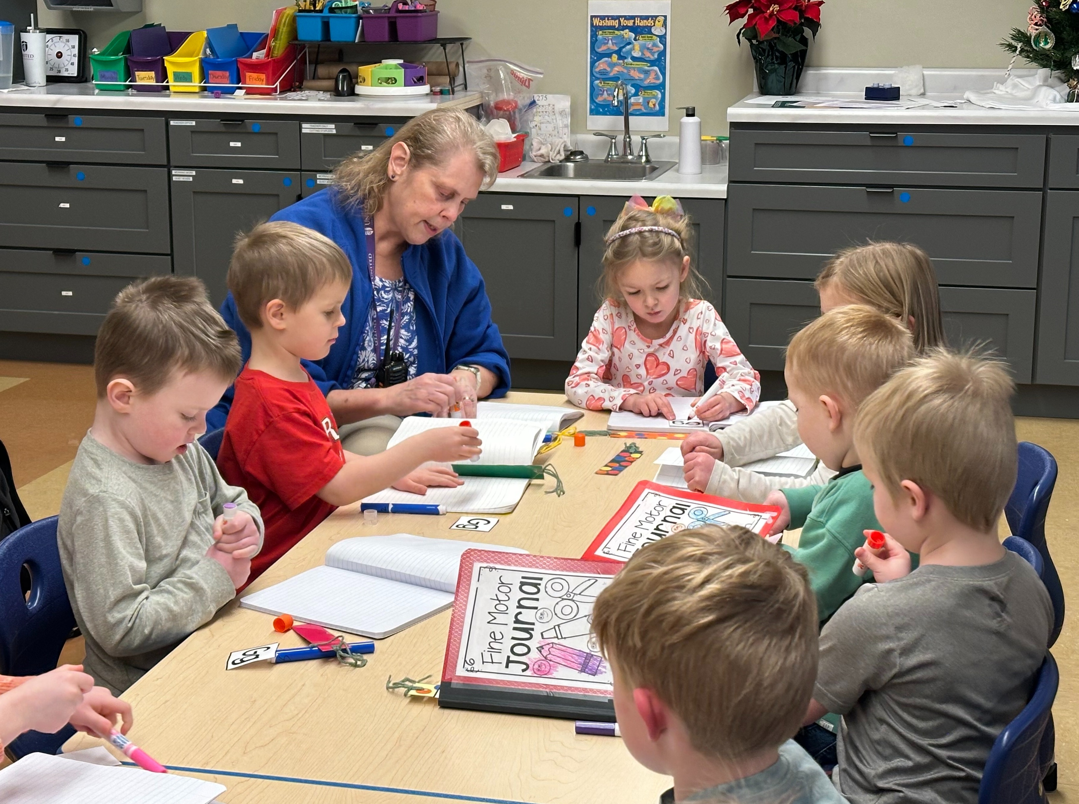 preK teacher working with students on fine motor skills