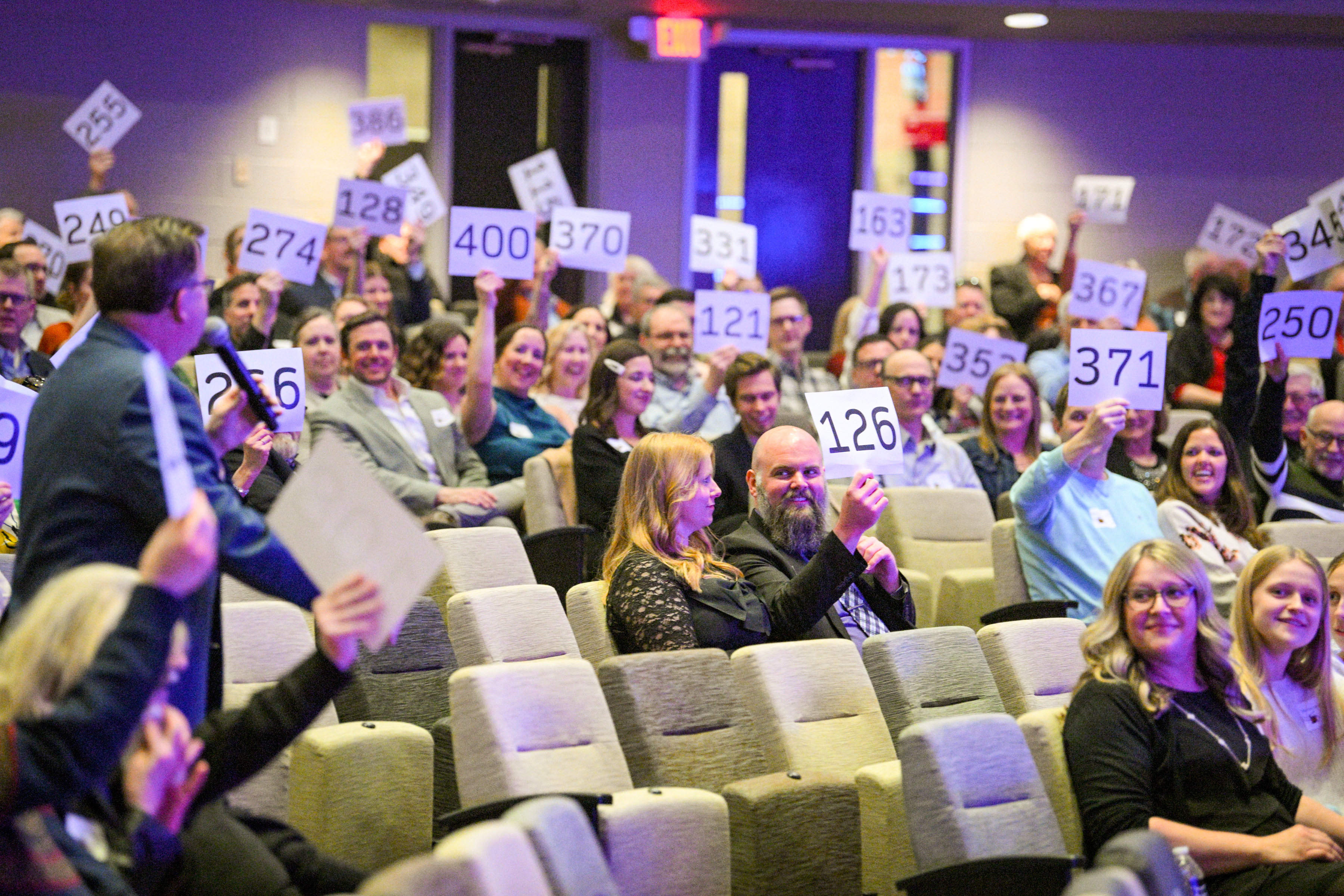 bidders raising their paddle to bid at a silent auction