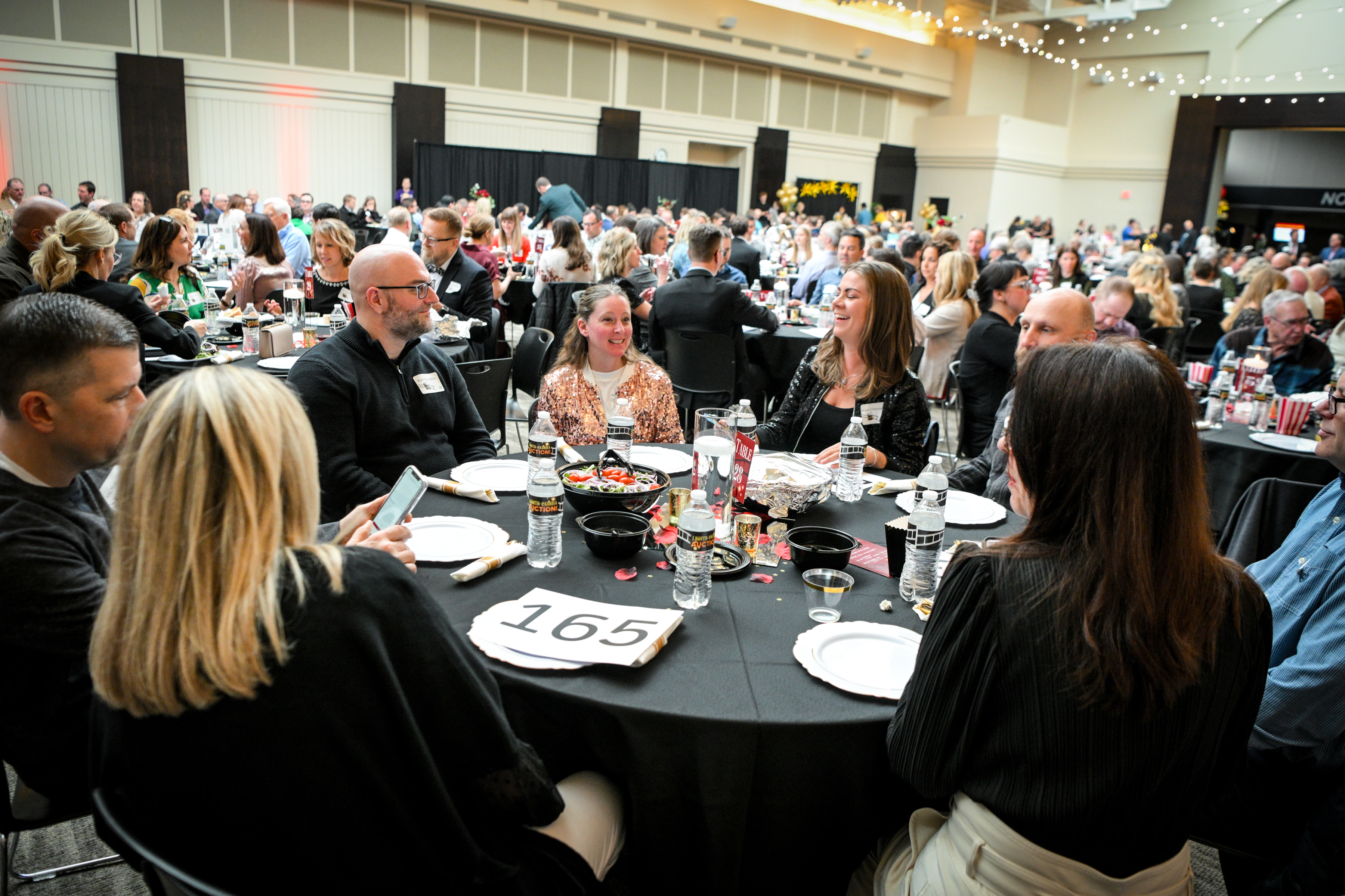 group of people sitting at a round table at a fundraising event