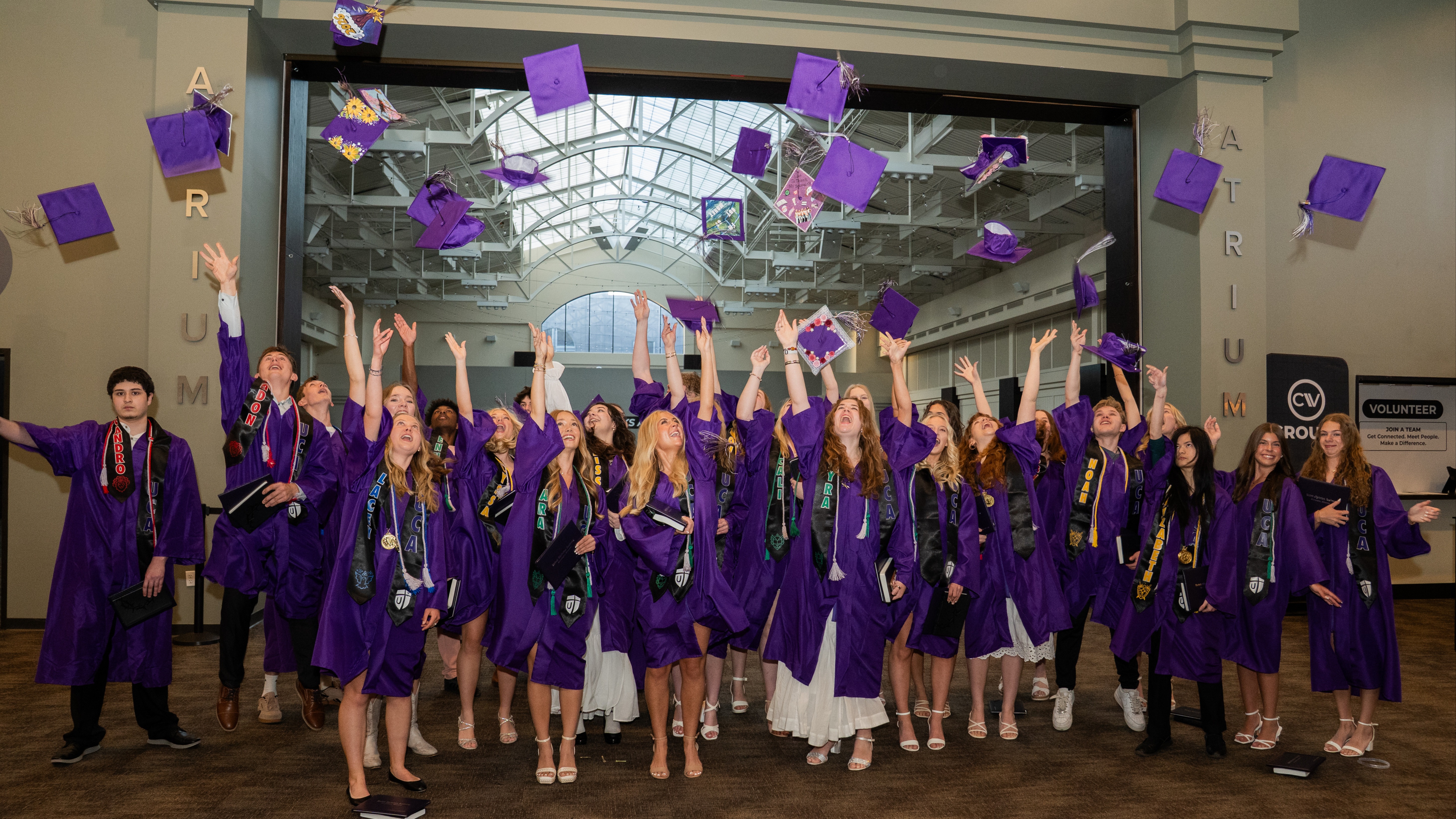 Group photo of high school graduates throwing their caps in the air