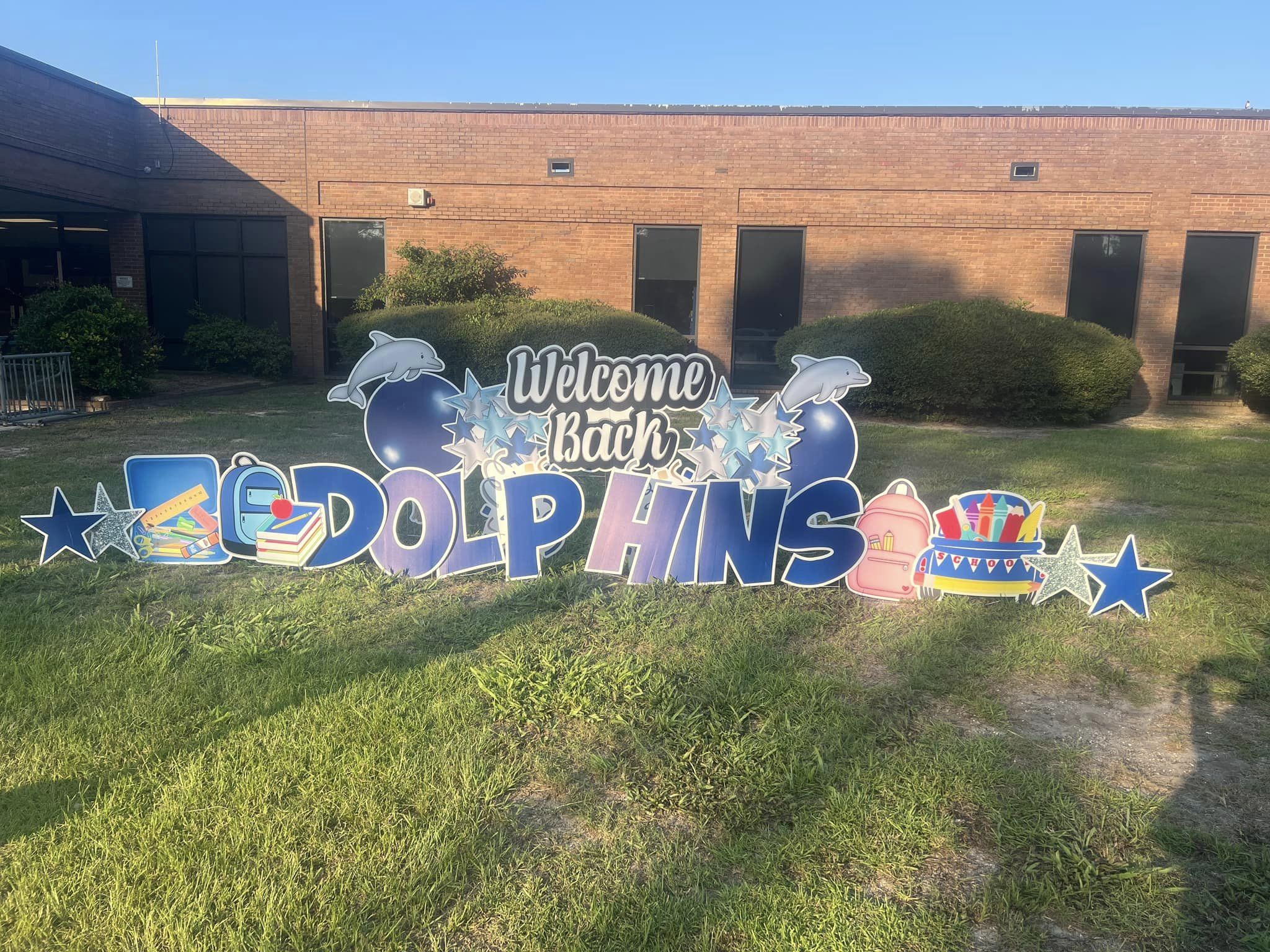 Welcome Back Dolphins Yard Sign in front of school building