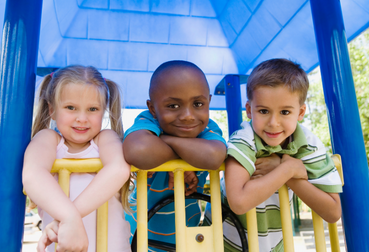 Students posing for picture on a playground at CAPS Clubhouse