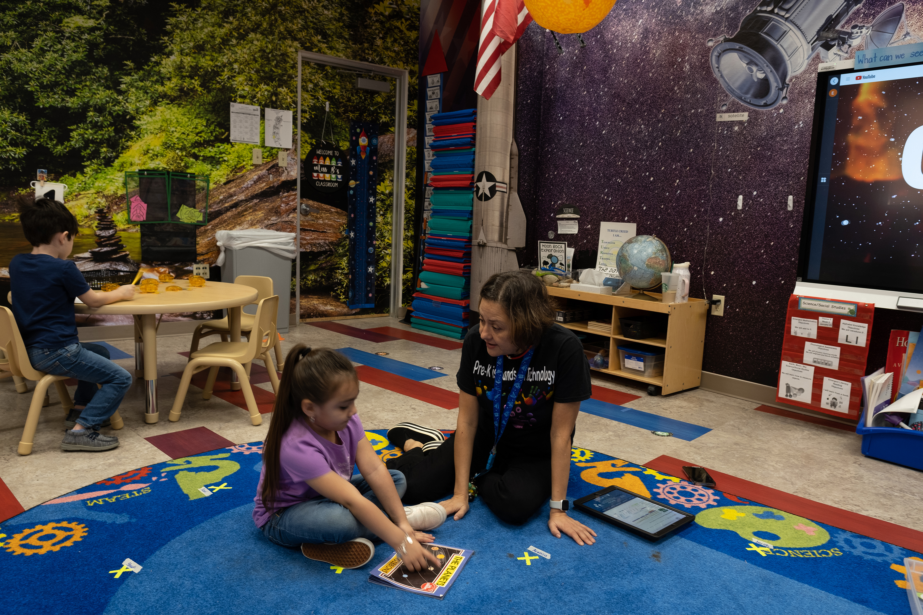 Teacher and Student sitting on the floor at classroom