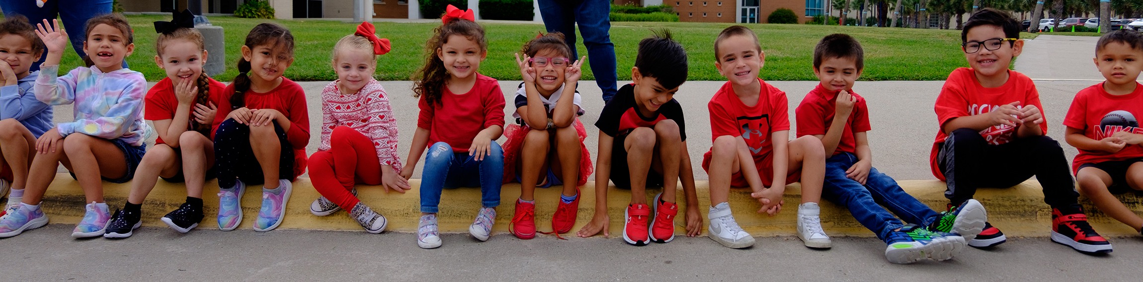 students sitting on curb with teacher