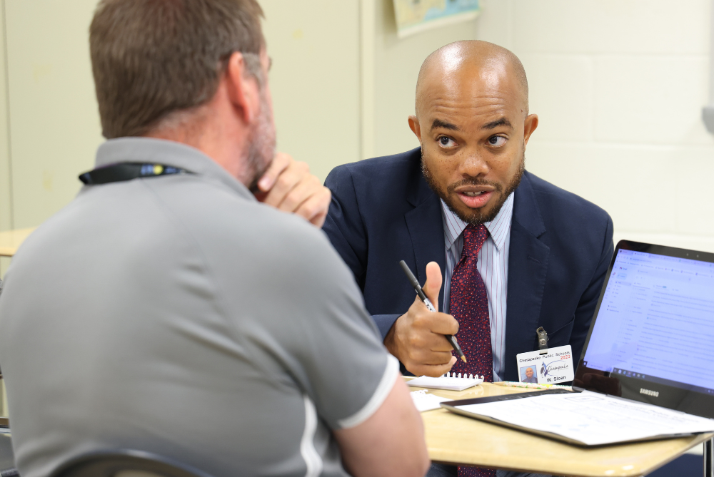 Two admin collaborate during a planning meeting.