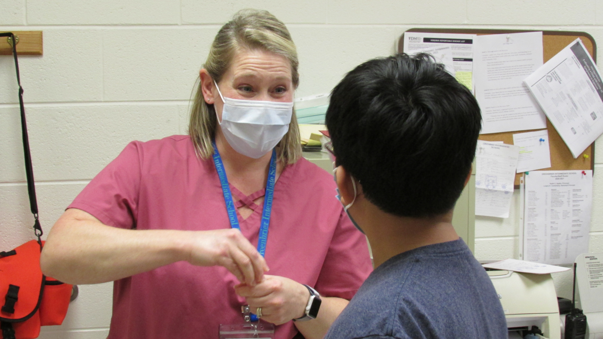 A school nurse talks to a student in a school clinic.